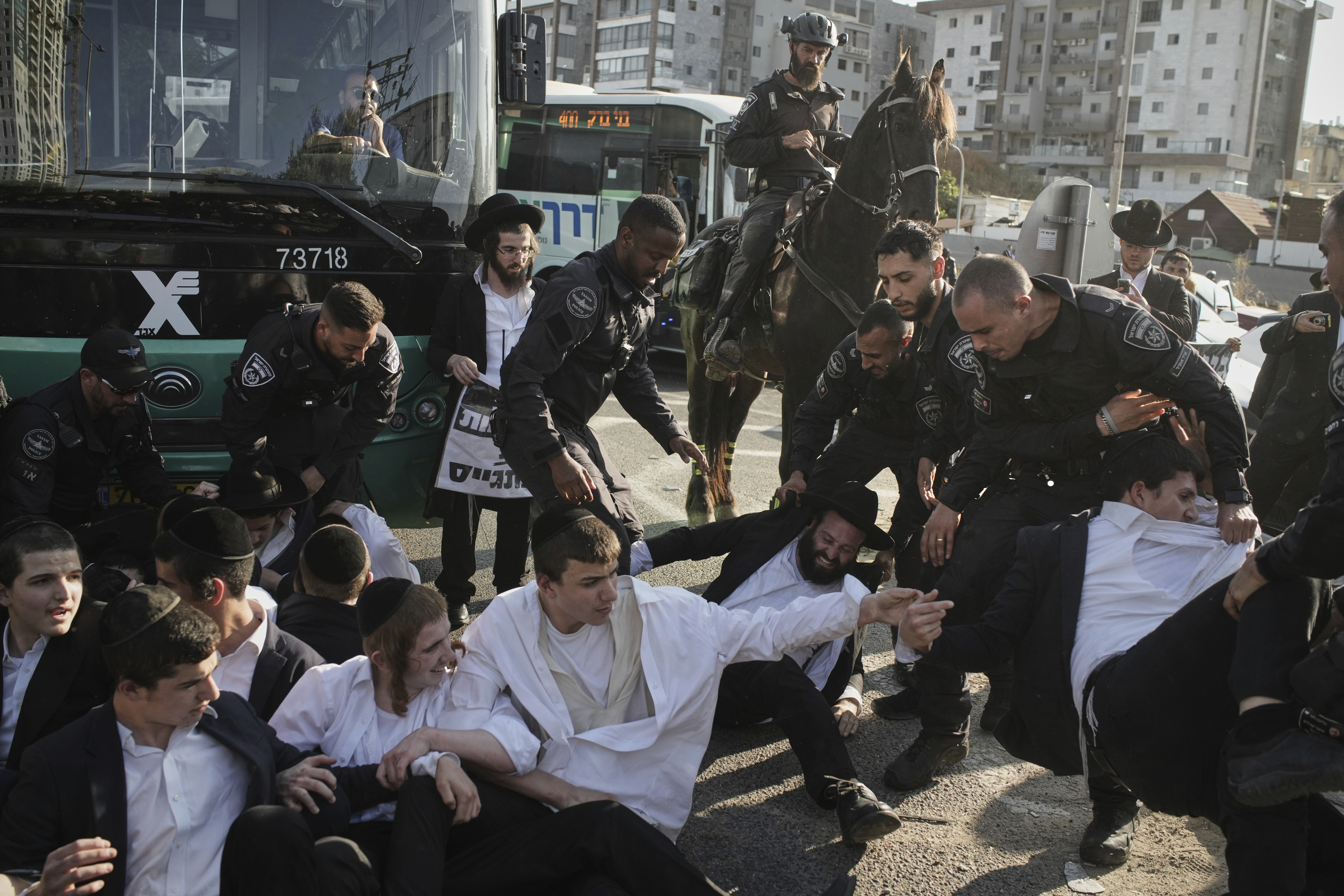 Israeli police officers disperse ultra-Orthodox Jewish men during a protest against army recruitment in Bnei Brak, Israel, Thursday, June 5, 2025. (AP Photo/Leo Correa)