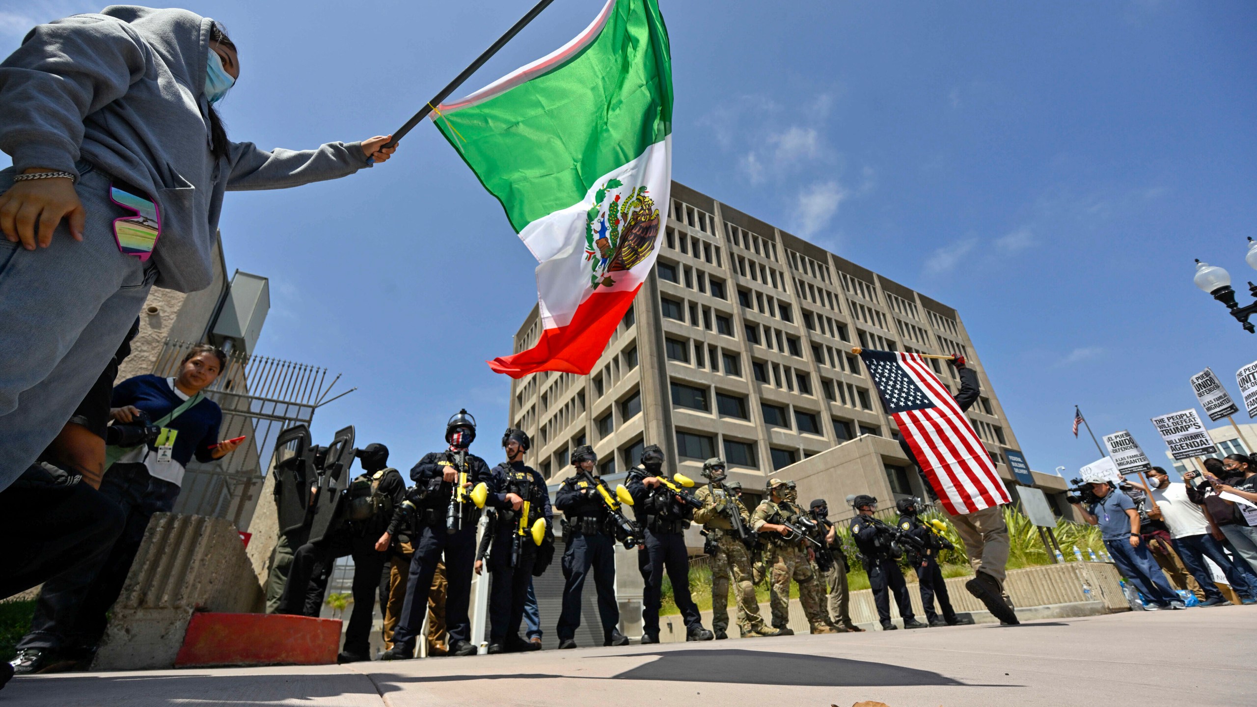 Protesters block the driveway to the Federal Building as police stand guard in Santa Ana, Calif., on Monday, June 9, 2025. (Jeff Gritchen/The Orange County Register via AP)