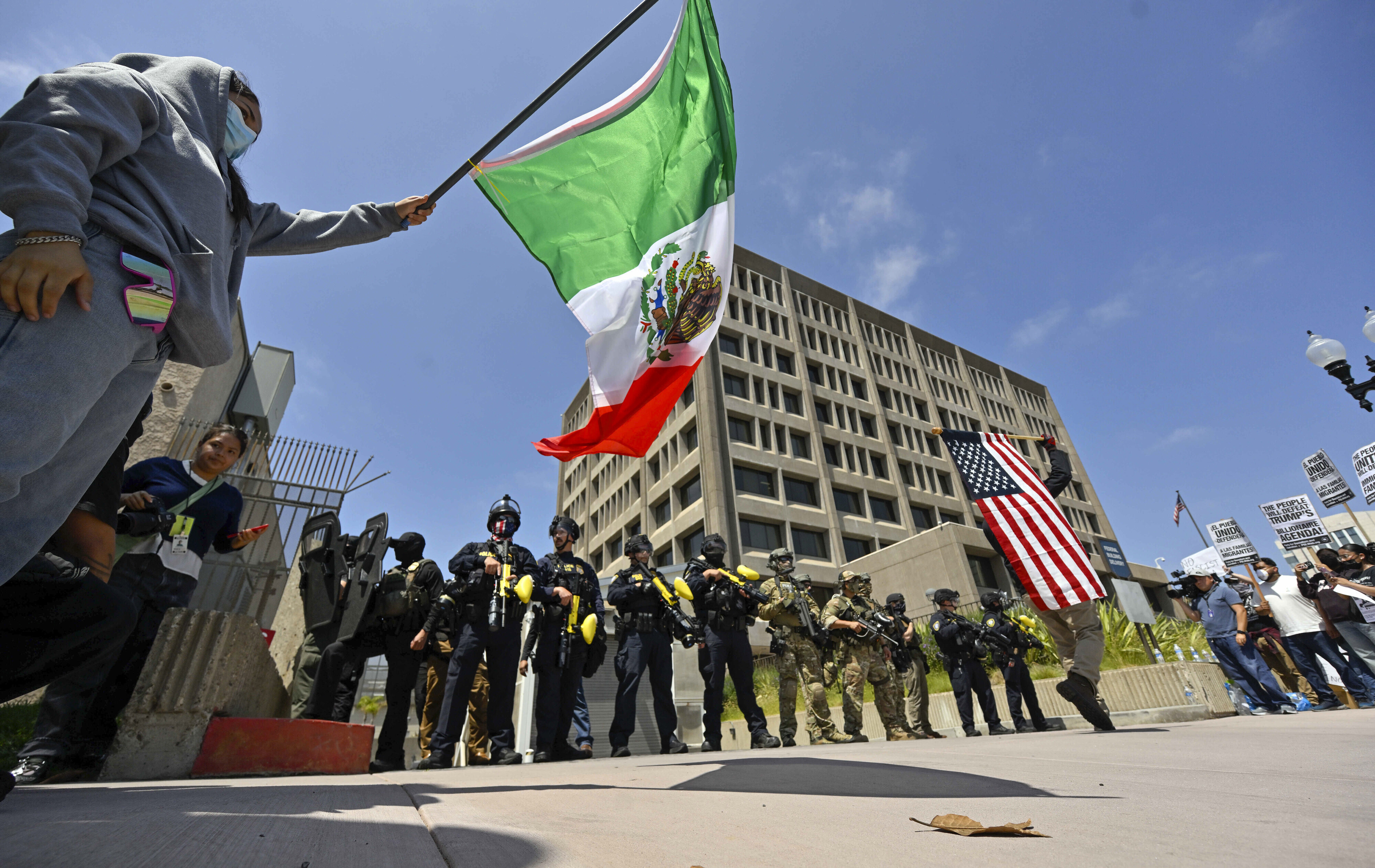 Protesters block the driveway to the Federal Building as police stand guard in Santa Ana, Calif., on Monday, June 9, 2025. (Jeff Gritchen/The Orange County Register via AP)