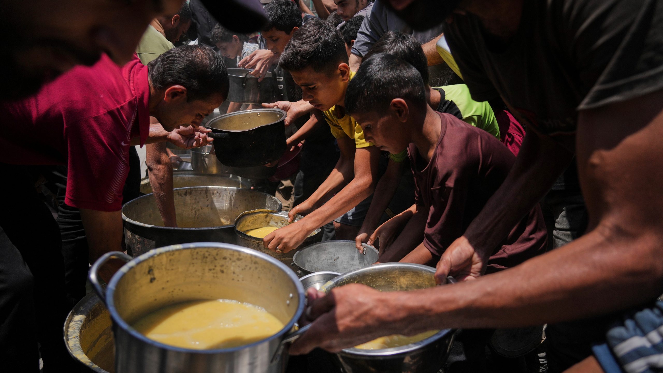 Palestinians receive donated food at a community kitchen in Gaza City, Tuesday, June 10, 2025. (AP Photo/Jehad Alshrafi)