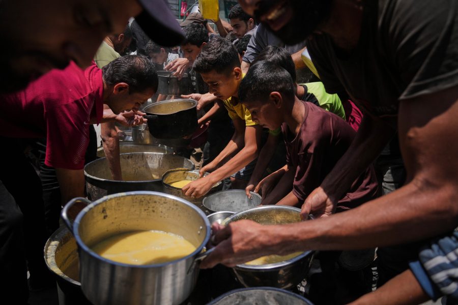 Palestinians receive donated food at a community kitchen in Gaza City, Tuesday, June 10, 2025. (AP Photo/Jehad Alshrafi)