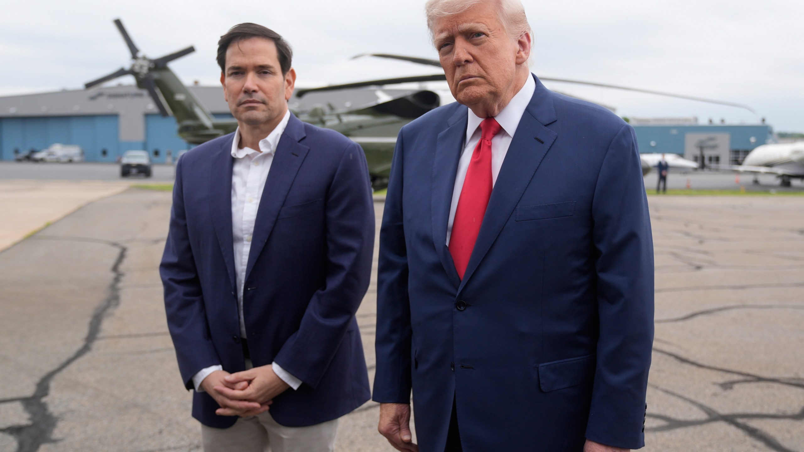 President Donald Trump, right, listens to a question from a reporter alongside Secretary of State Marco Rubio upon arriving at Morristown Municipal Airport in Morristown, N.J., en route to Camp David, Md., Sunday, June 8, 2025. (AP Photo/Manuel Balce Ceneta)