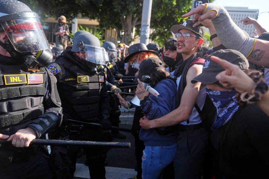 Protesters confront police on the 101 Freeway near the metropolitan detention center of downtown Los Angeles, Sunday, June 8, 2025, following last night's immigration raid protest. (AP Photo/Jae C. Hong)