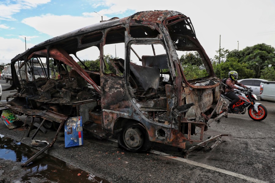 A bus that exploded next to a police station sits on a road in Villa Rica, Cauca Valley, Colombia, Tuesday, June 10, 2025. (AP Photo/Santiago Saldarriaga)