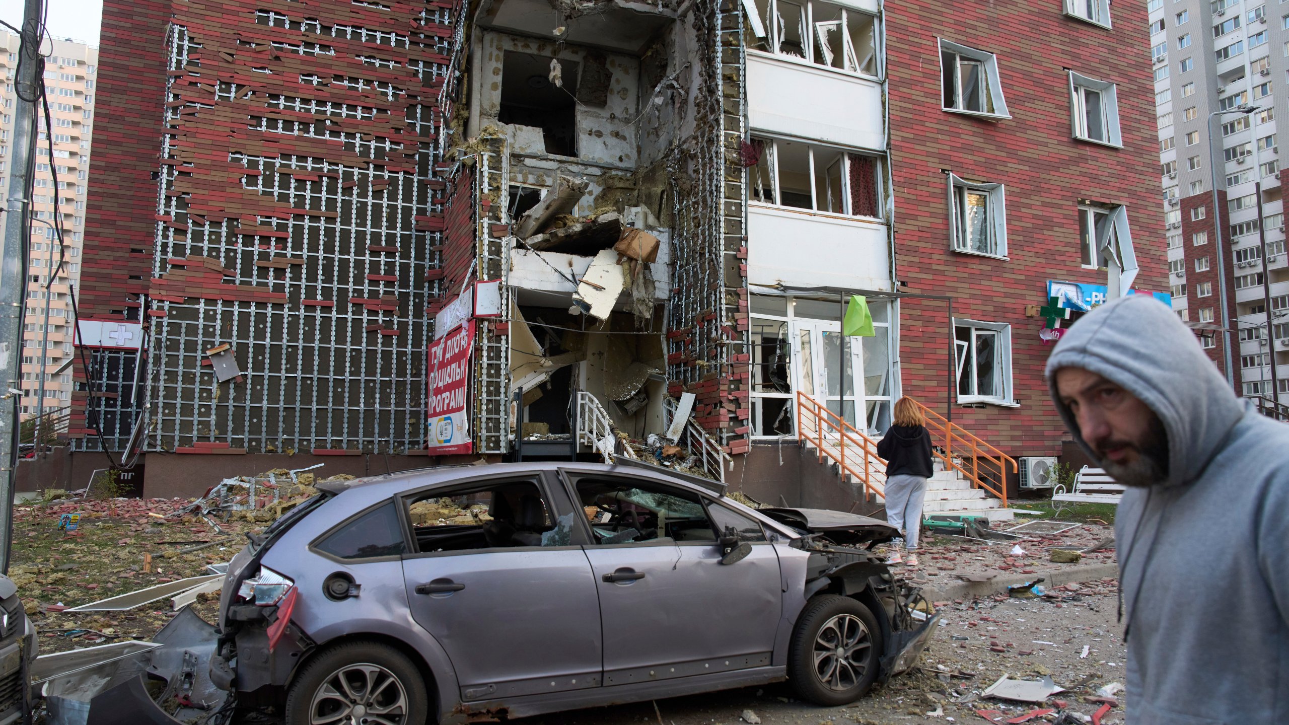 Residents react near their damaged multi-storey building damaged in Russia's missile and drone attack in Kyiv, Ukraine, Tuesday, June 10, 2025. (AP Photo/Efrem Lukatsky)