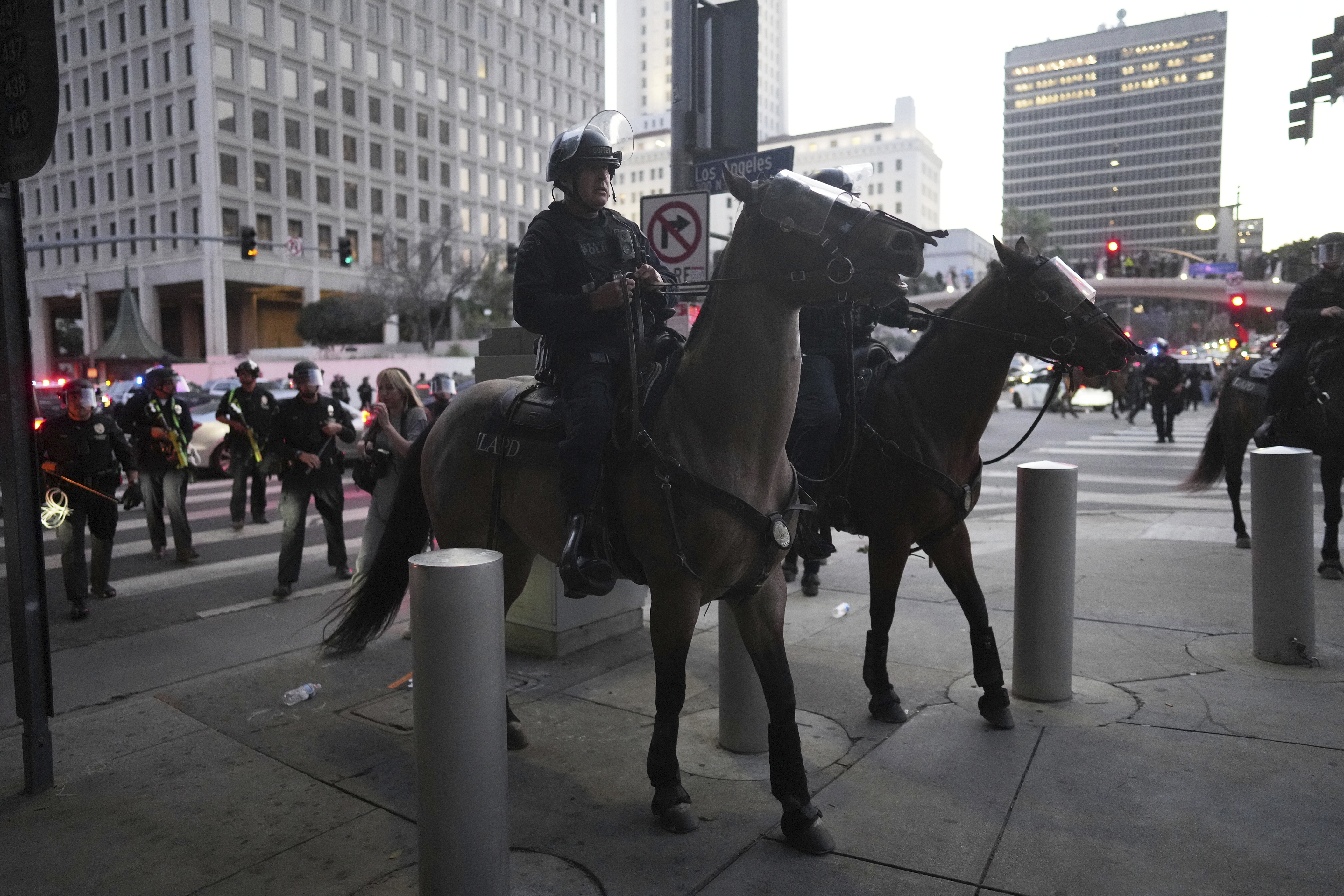 Los Angeles Police Department officers on horseback move through a street during a protest on Tuesday, June 10, 2025, in Los Angeles. (AP Photo/Eric Thayer)