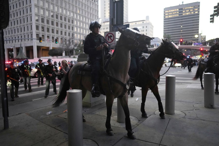 Los Angeles Police Department officers on horseback move through a street during a protest on Tuesday, June 10, 2025, in Los Angeles. (AP Photo/Eric Thayer)