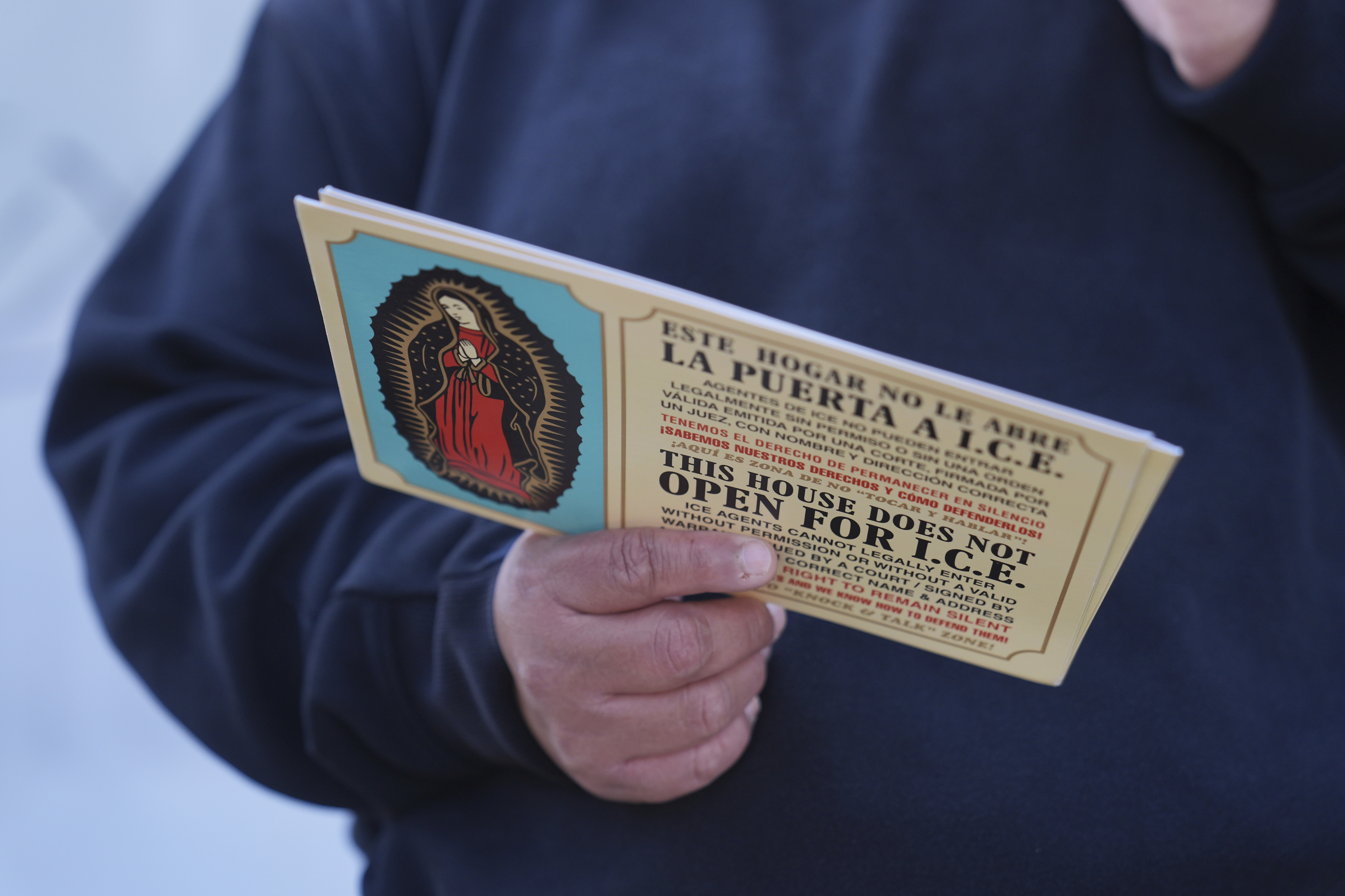 FILE - A woman outside Ambiance Apparel holds a card about Immigration and Customs Enforcement after authorities conducted an operation, Friday, June 6, 2025, in Los Angeles. (AP Photo/Jae C. Hong, File)