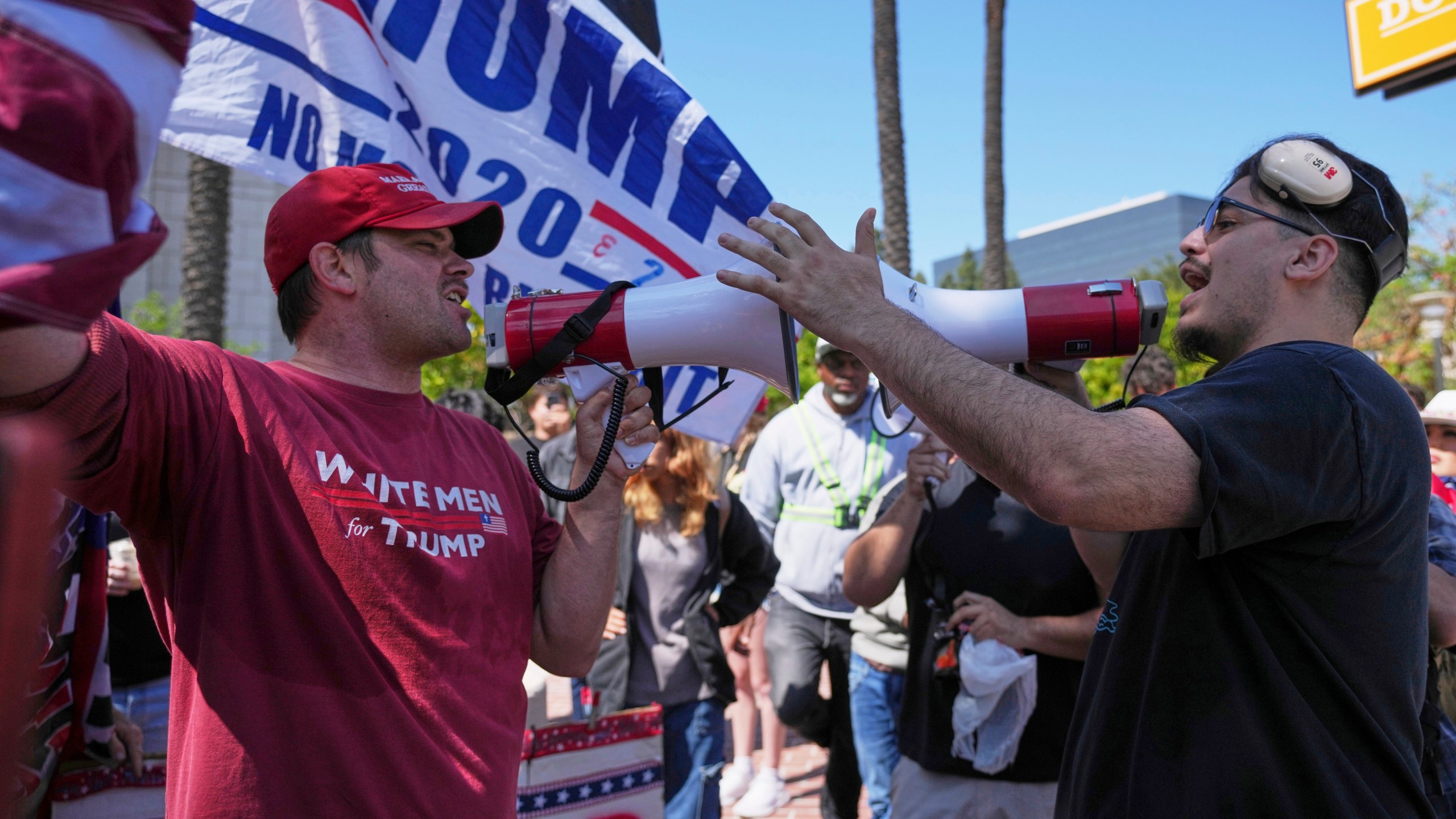 A protester wearing a shirt reading "WHITE MEN for TRUMP" argues with another protester Tuesday, June 10, 2025, in Santa Ana, Calif. (AP Photo/Jae C. Hong)