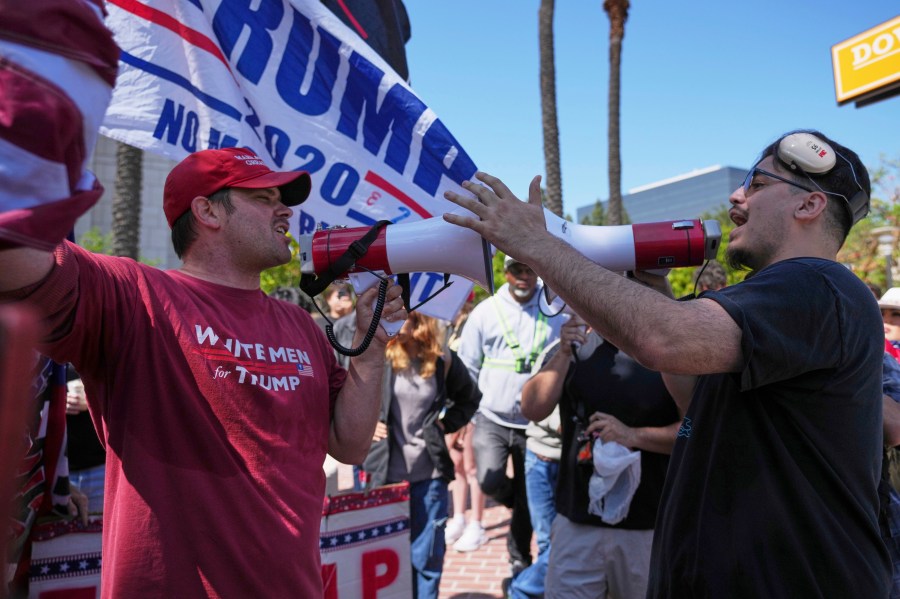 A protester wearing a shirt reading "WHITE MEN for TRUMP" argues with another protester Tuesday, June 10, 2025, in Santa Ana, Calif. (AP Photo/Jae C. Hong)