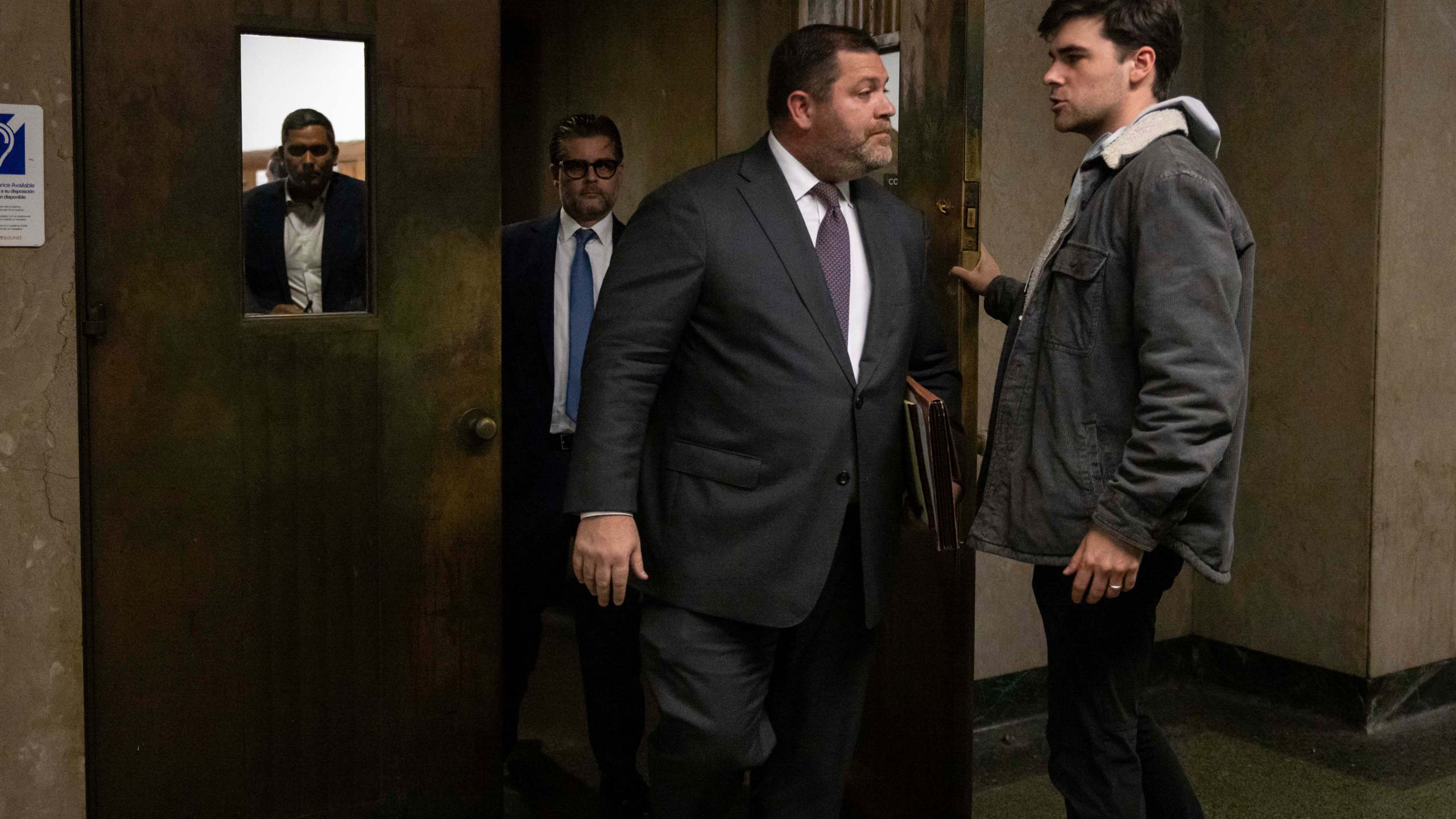 Wayne Gosnell, center, attorney for John Woeltz, cryptocurrency investor charged for kidnapping and false imprisonment, exits a courtroom, Wednesday, May 28, 2025, in New York. (AP Photo/Yuki Iwamura)
