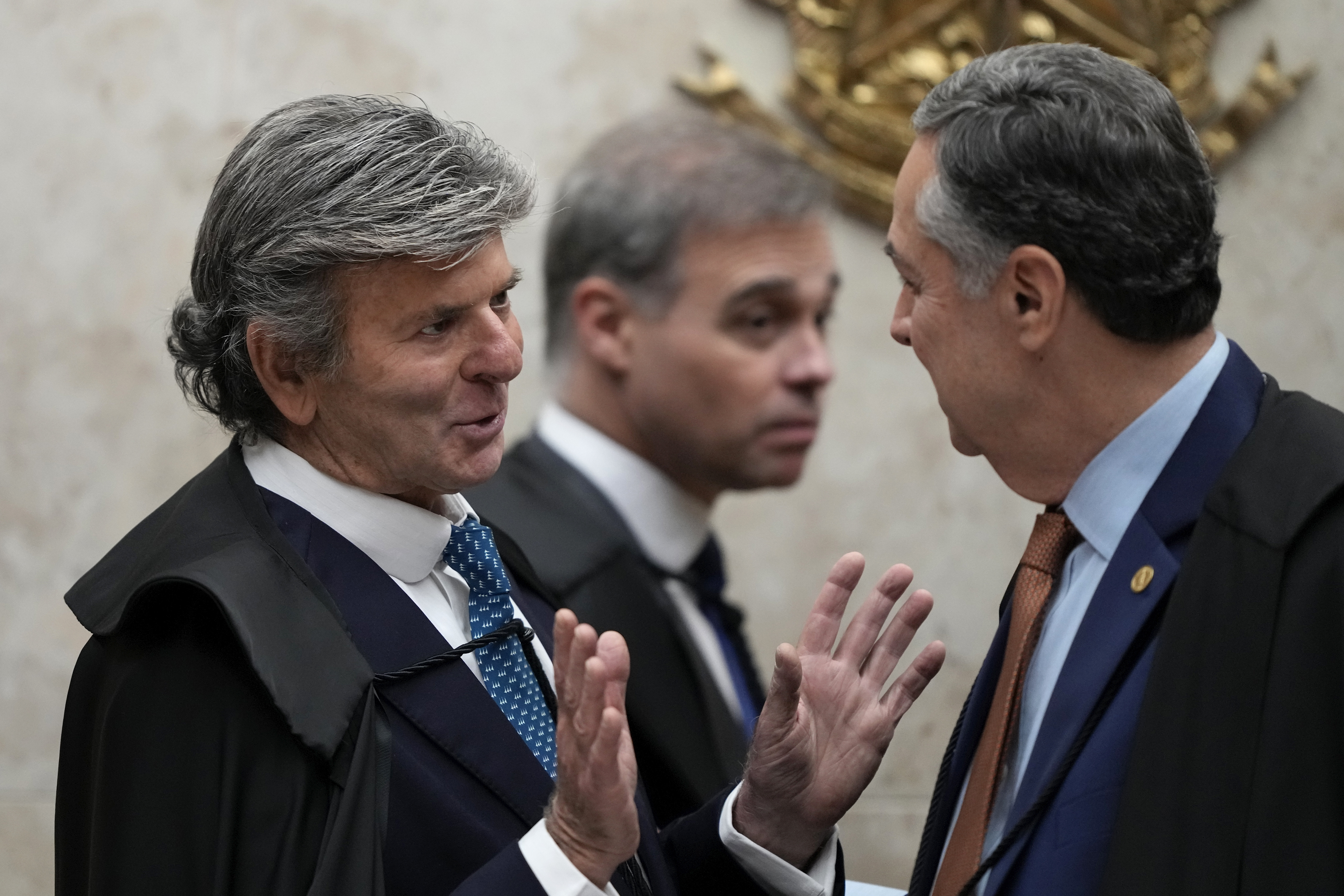 Minister Luiz Fux, left, Google Brazil’s rapporteur, talks with Supreme Court Chief Justice Roberto Barroso, during the court’s resumption of social media regulation cases regarding online disinformation, in Brasilia, Brazil, Wednesday, June 4, 2025. (AP Photo/Eraldo Peres)