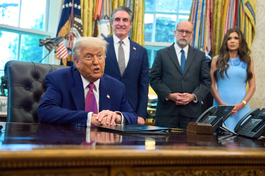 President Donald Trump speaks with reporters in the Oval Office of the the White House, Tuesday, June 10, 2025, in Washington, as from left, Interior Secretary Doug Burgum, Office of Management and Budget Director Russell Vought, and Homeland Security Secretary Kristi Noem, listen. (AP Photo/Evan Vucci)