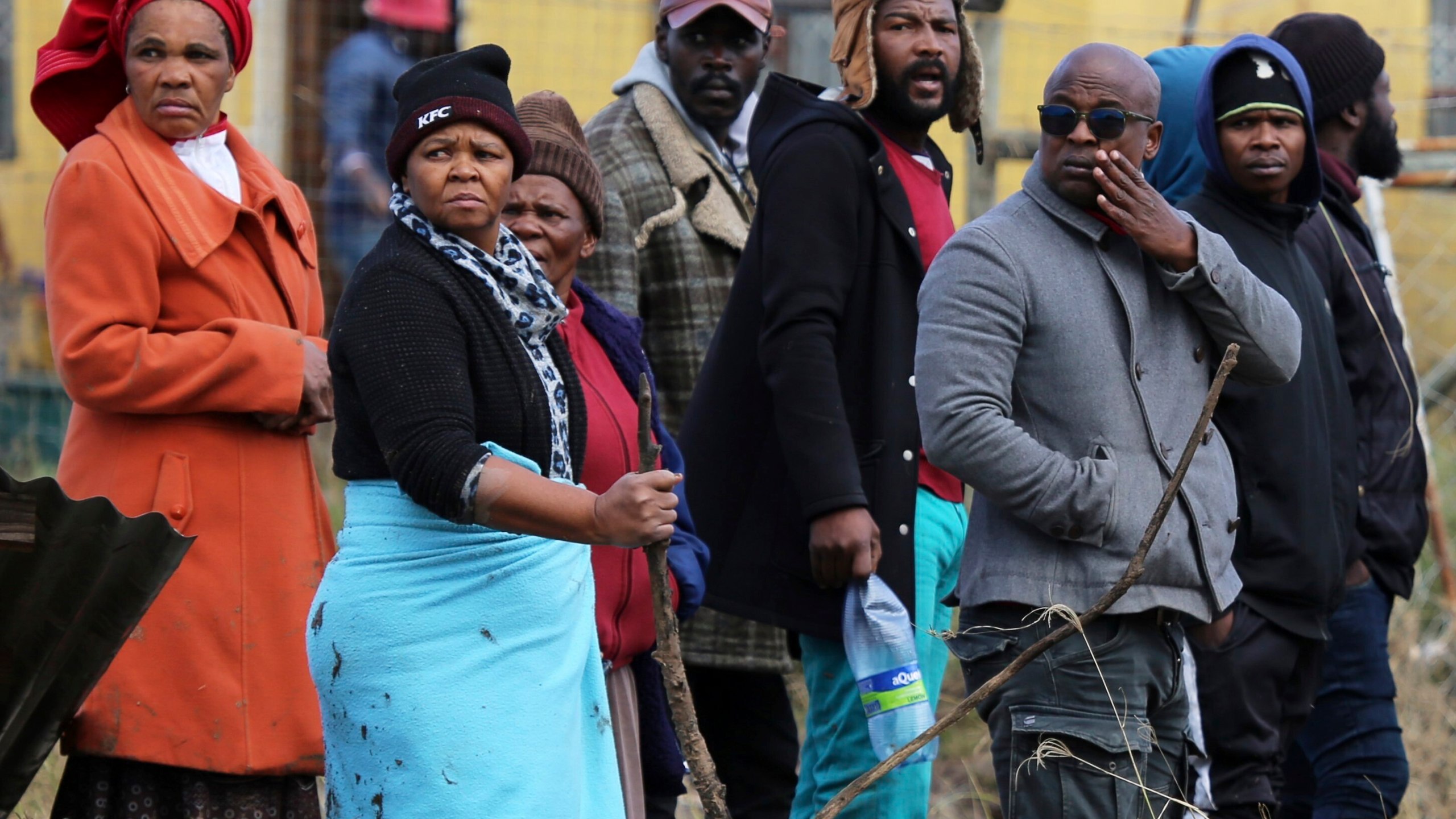 Community members and families watch as rescue workers recover bodies after floods swept through the area in Mthatha, South Africa, Wednesday, June 11, 2025. (AP Photo/Hoseya Jubase)