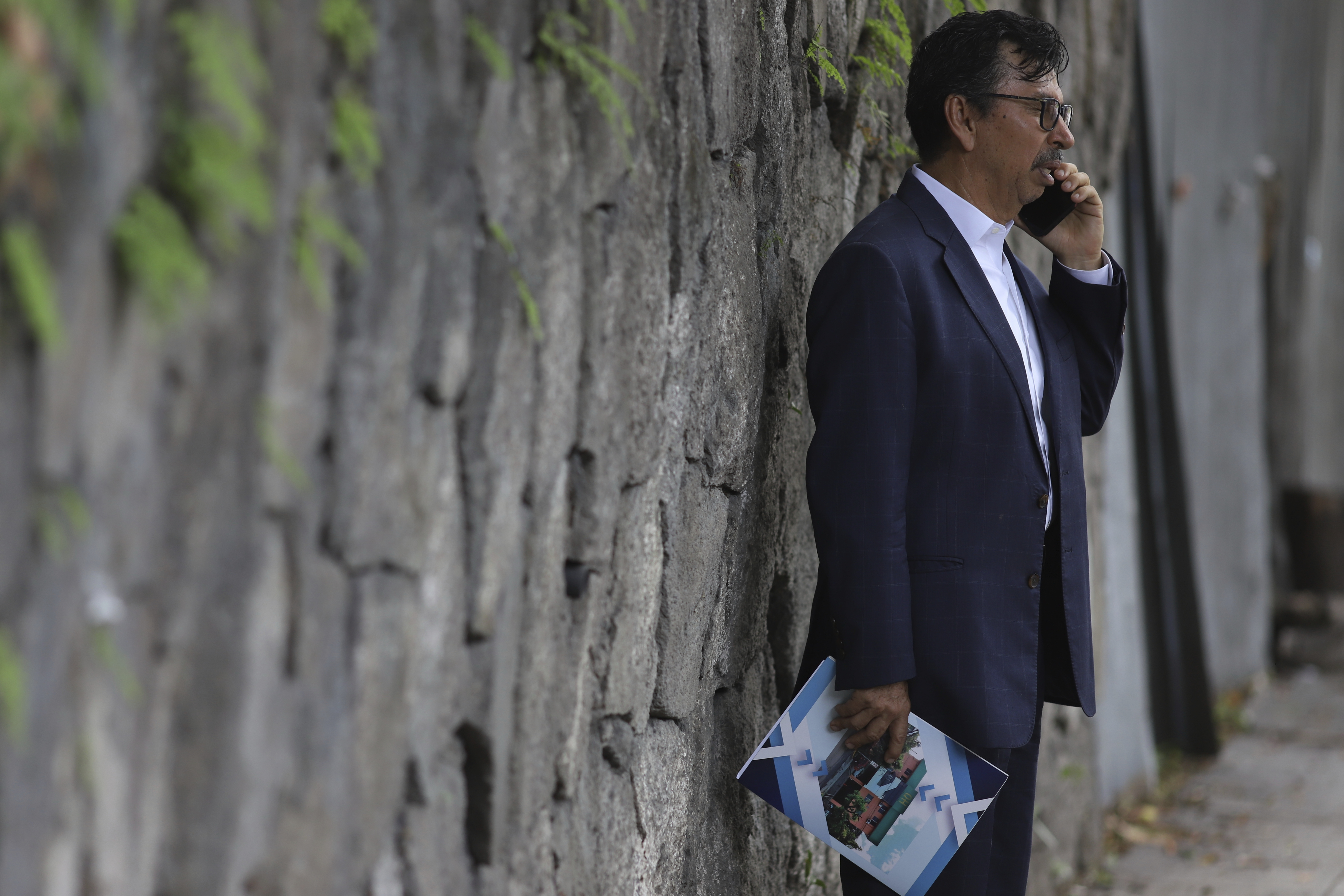 Jaime Quintanilla, attorney for Salvador Enrique Anaya, a critic of President Nayib Bukele's government, speaks on his cell phone outside a police station after arriving to visit his client in San Salvador, Tuesday, June 10, 2025. Anaya was detained on June 7 for alleged money laundering and asset laundering. (AP Photo/Salvador Melendez)