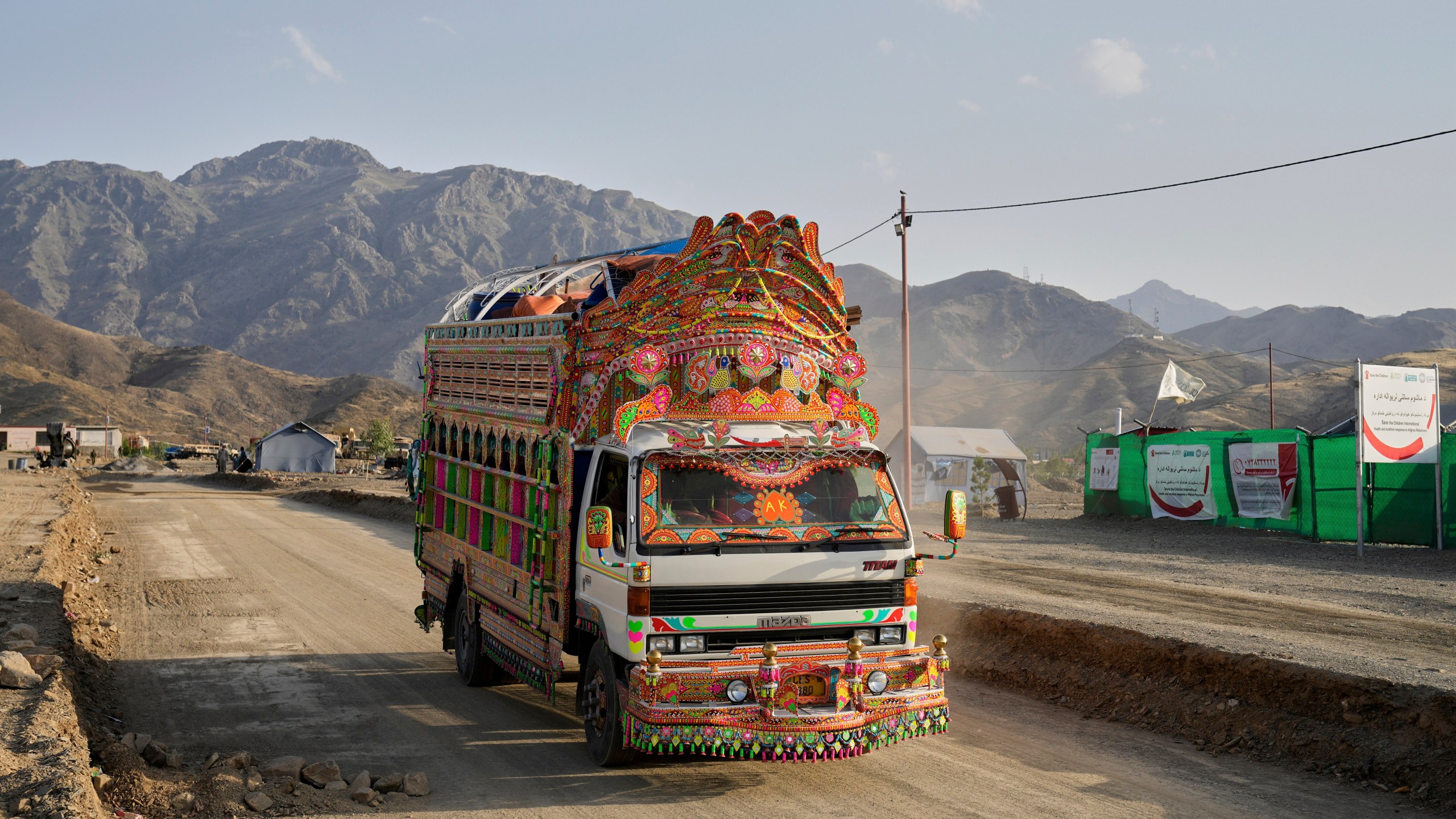 A Pakistani truck carrying repatriated Afghan refugees arrives at a camp near the Pakistan-Afghanistan border, in Torkham, Afghanistan, Saturday, May 31, 2025. (AP Photo/Ebrahim Noroozi)