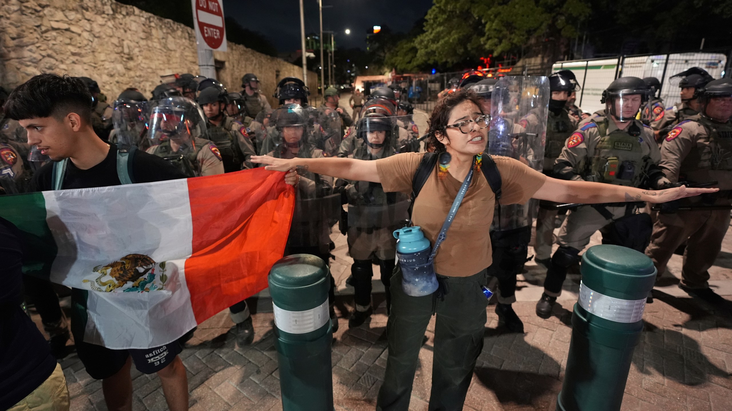 Anti ICE protesters gather near the Alamo as Texas state troopers keep watch in downtown San Antonio, Wednesday, June 11, 2025. (AP Photo/Eric Gay)
