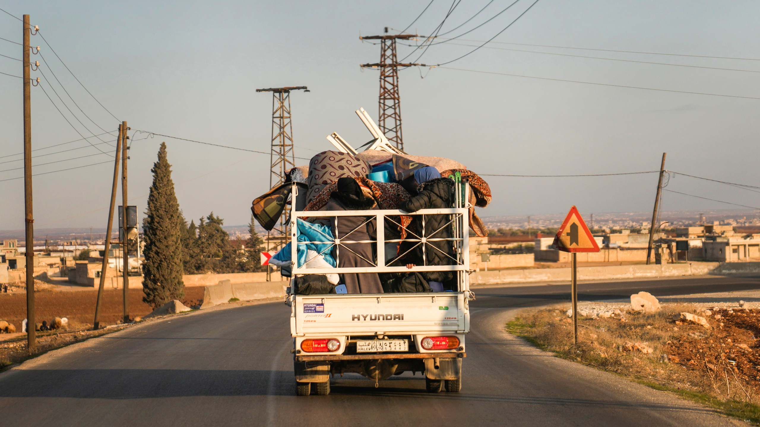 FILE - Syrian refugee Ahmed al-Kassem and his family drive a truck loaded with their belongings from Turkey, on the their way back to the family's home in Aleppo, Syria, Friday, Dec. 13, 2024. (AP Photo/Khalil Hamra, File)