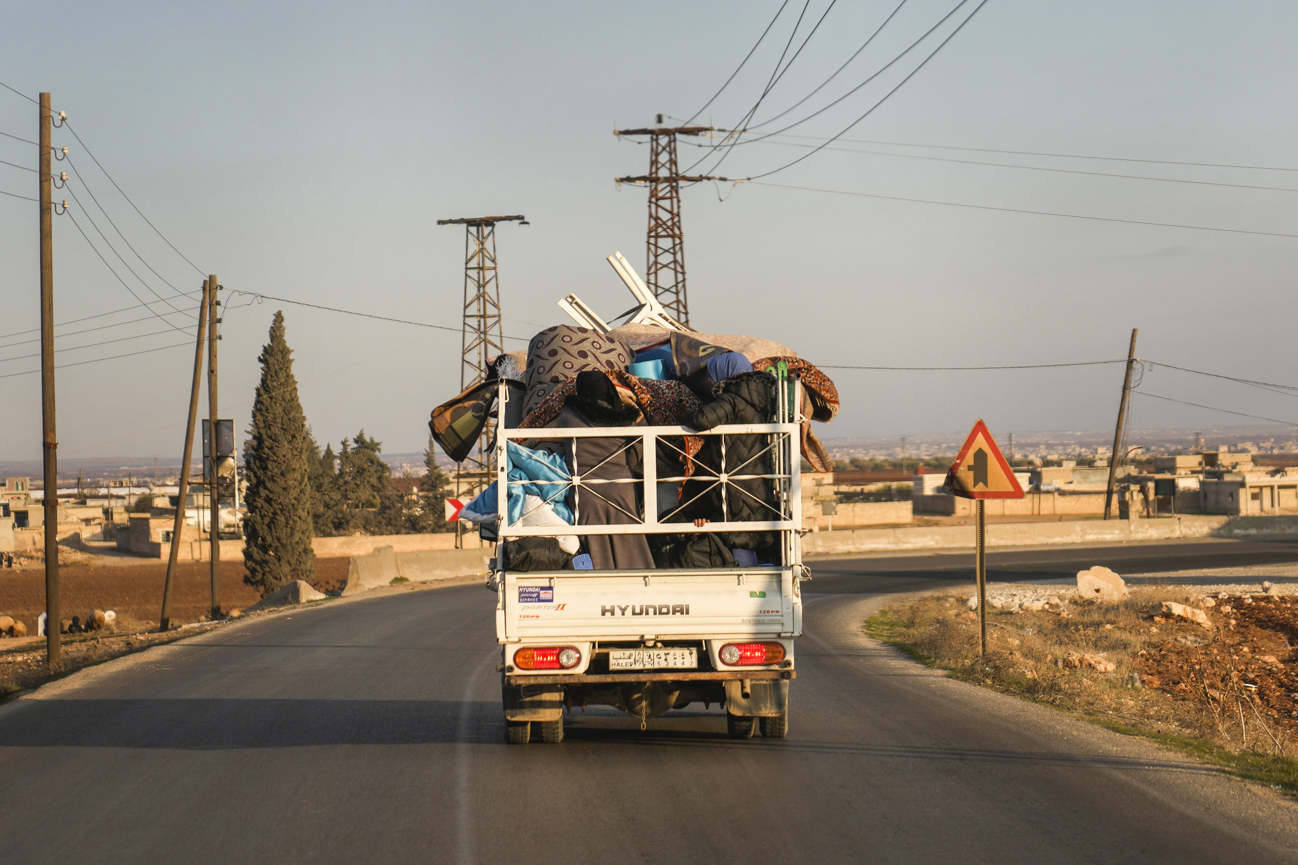 FILE - Syrian refugee Ahmed al-Kassem and his family drive a truck loaded with their belongings from Turkey, on the their way back to the family's home in Aleppo, Syria, Friday, Dec. 13, 2024. (AP Photo/Khalil Hamra, File)