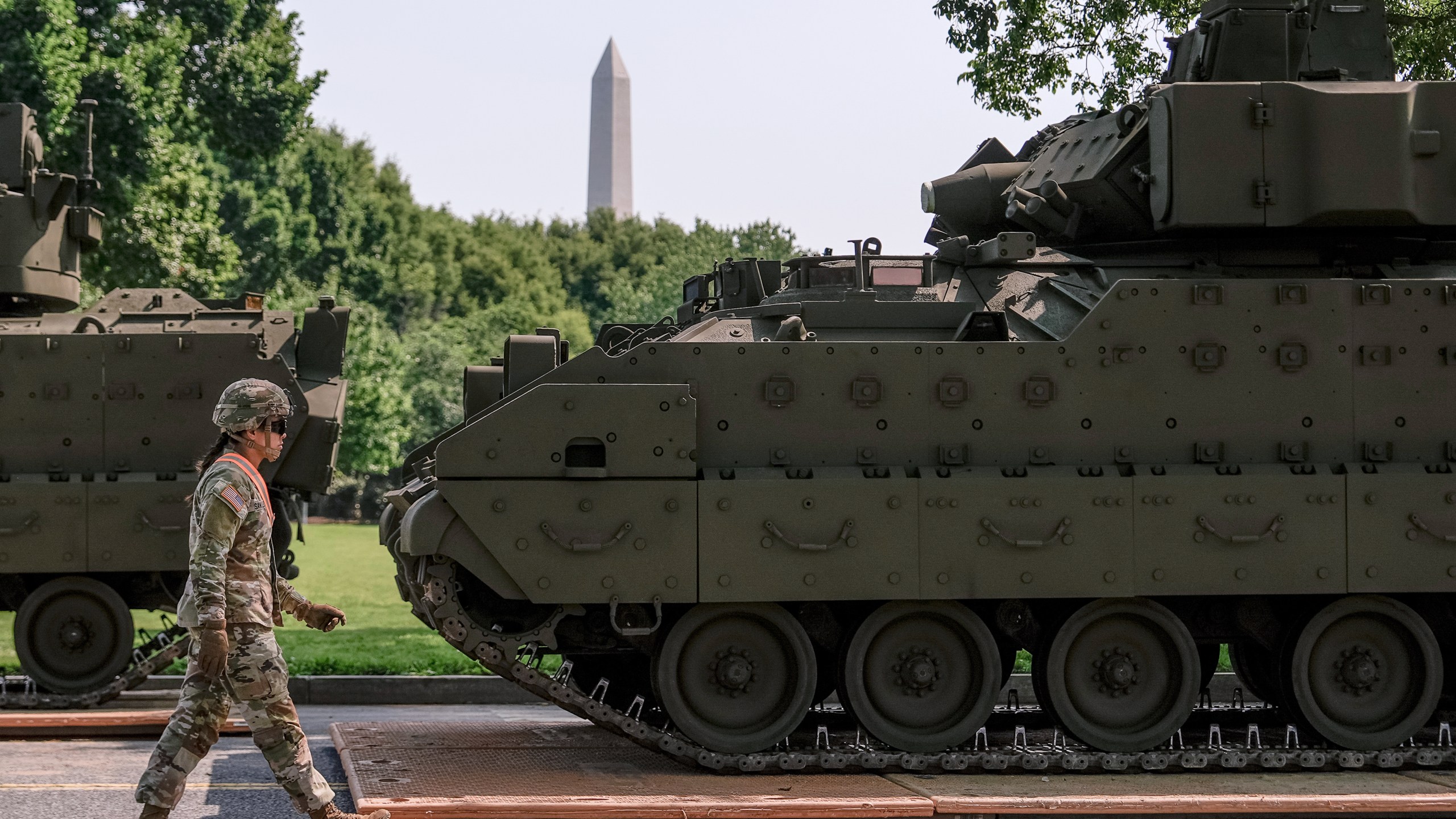 A U.S. Army soldier walks past a Bradley fighting vehicle staged in West Potomac Park ahead of an upcoming military parade commemorating the Army's 250th anniversary and coinciding with Donald Trump's 79th birthday, Wednesday, June 11, 2025, in Washington. (AP Photo/Julia Demaree Nikhinson)