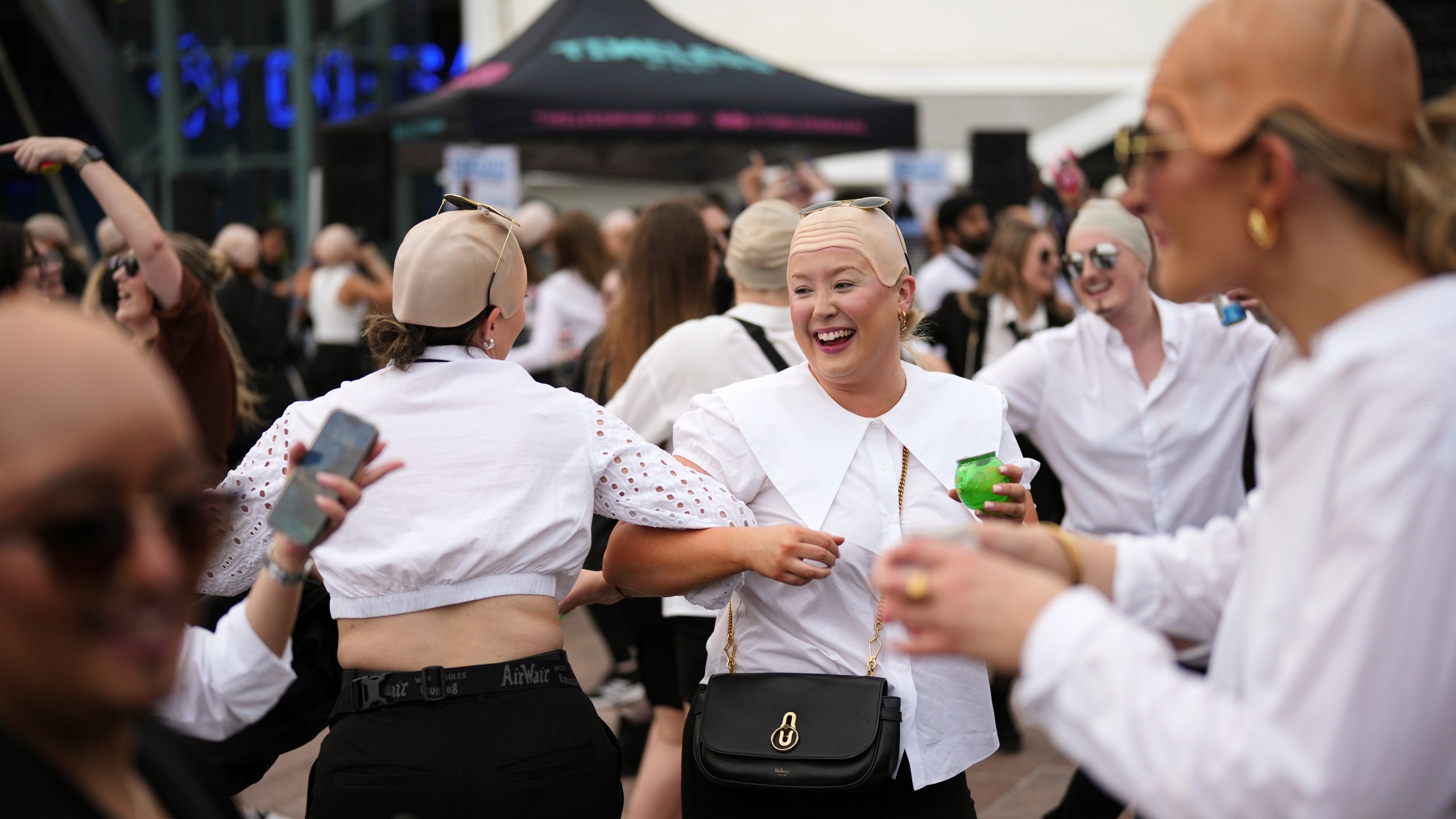 Fans dance in front of the O2 Arena prior to a performance by Pitbull on Monday, June 9, 2025, in London. (Photo by Scott A Garfitt/Invision/AP)