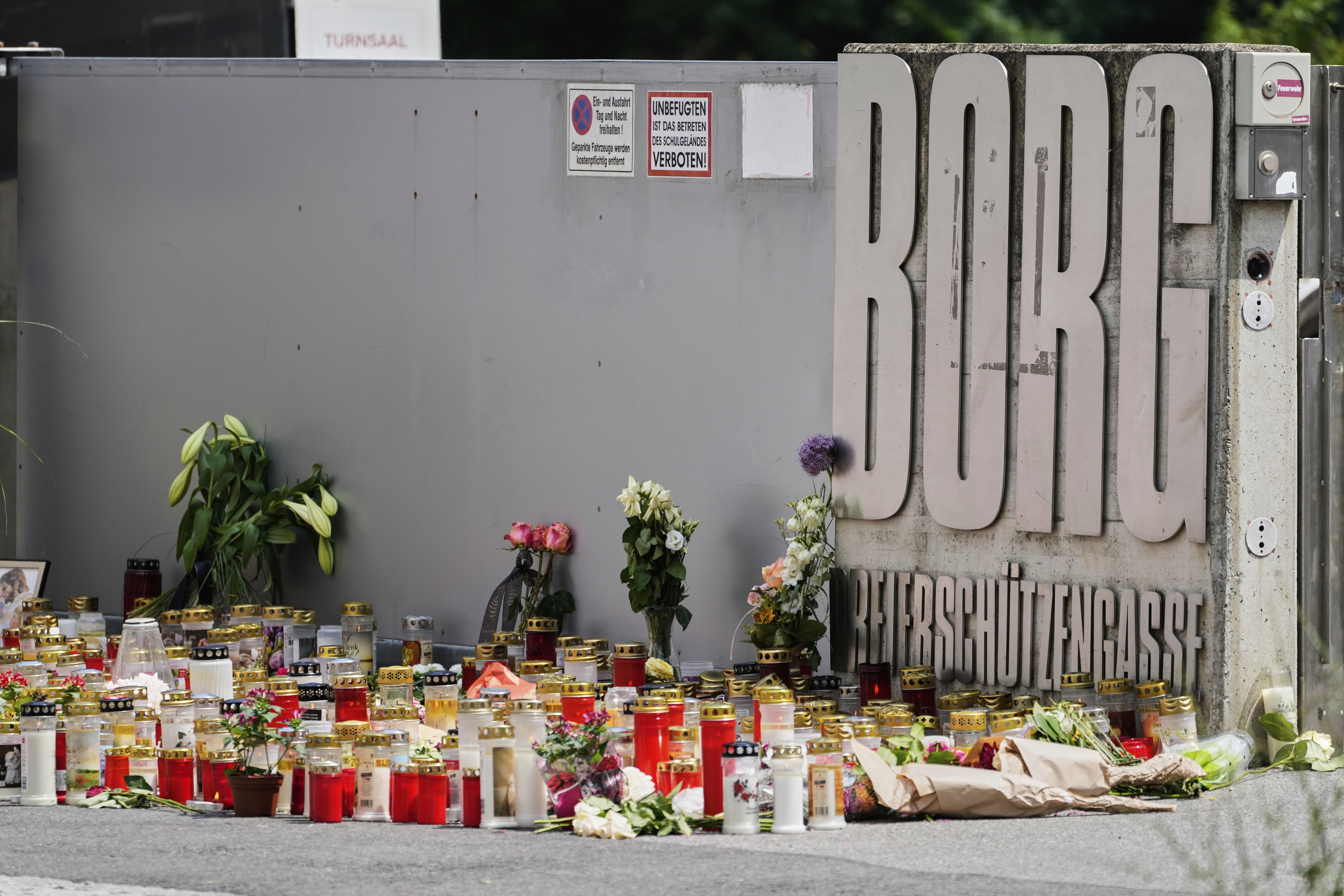 Flowers and candles are laid outside a school where a former student opened fire the day before fatally wounding several people and injuring many others before taking his own life, Graz, Austria, Wednesday, June 11, 2025. (AP Photo/Darko Bandic)