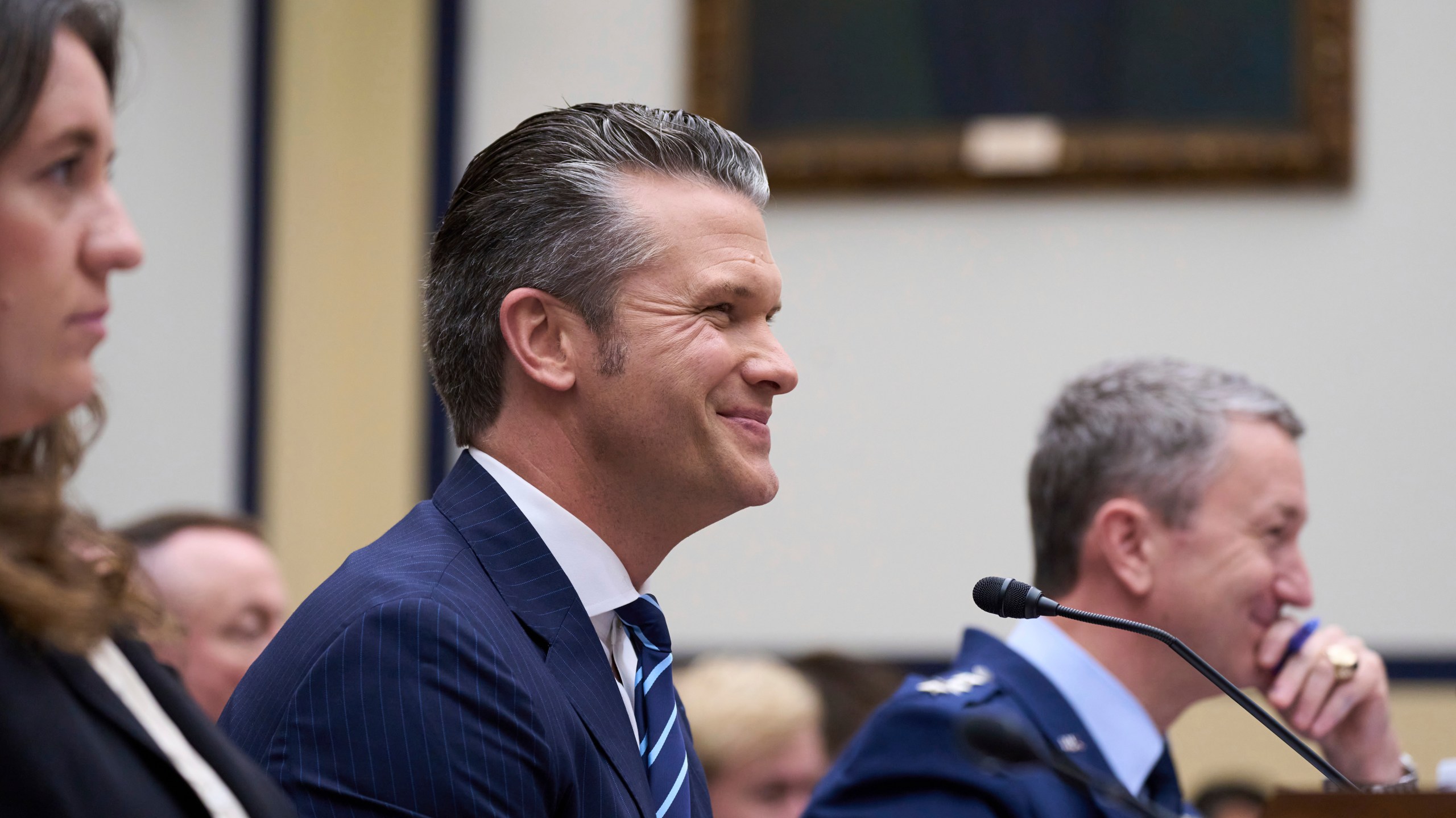 Secretary of Defense Pete Hegseth, flanked by Bryn MacDonnell, left, acting chief financial officer at the Department of Defense, and Gen. Dan Caine, chairman of the Joint Chiefs of Staff, fields questions on the Pentagon budget from the House Armed Services Committee, at the Capitol in Washington, Thursday, June 12, 2025. (AP Photo/J. Scott Applewhite)
