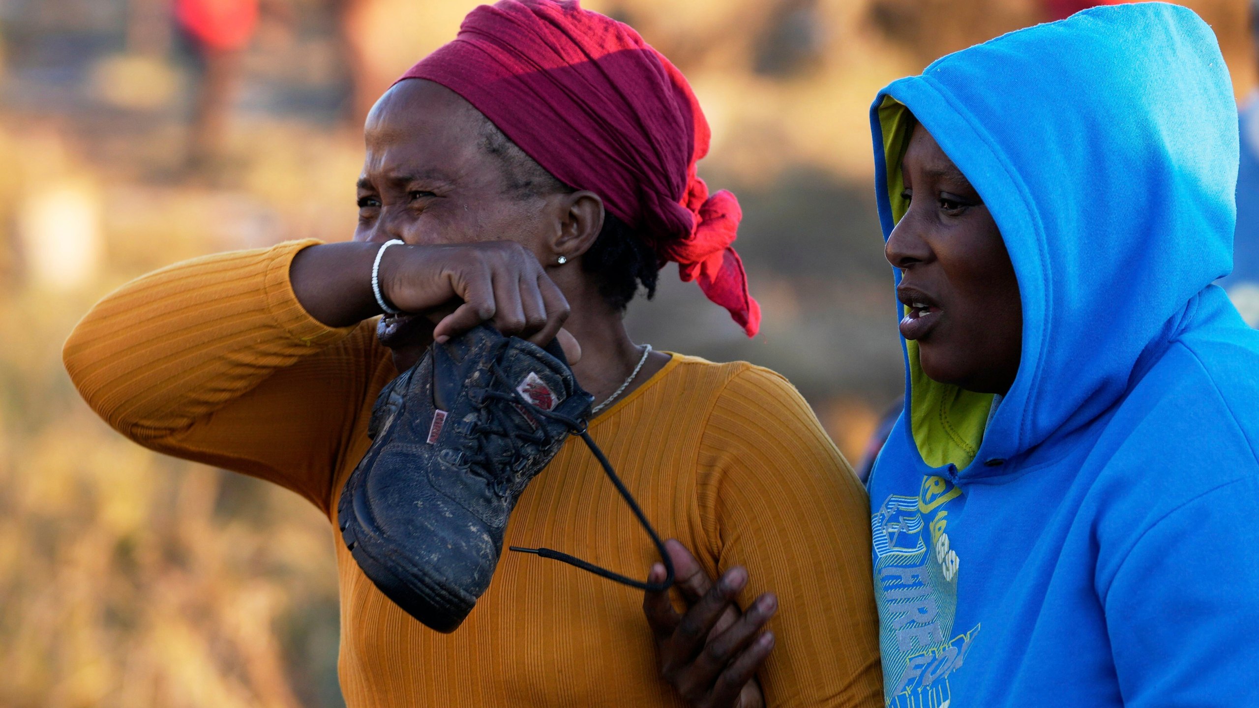 A relative reacts as bodies of her sister and three daughters were retrieved from inside a one room house, after floods swept through the area in Mthatha, South Africa, Thursday, June 12, 2025. (AP Photo/Themba Hadebe)
