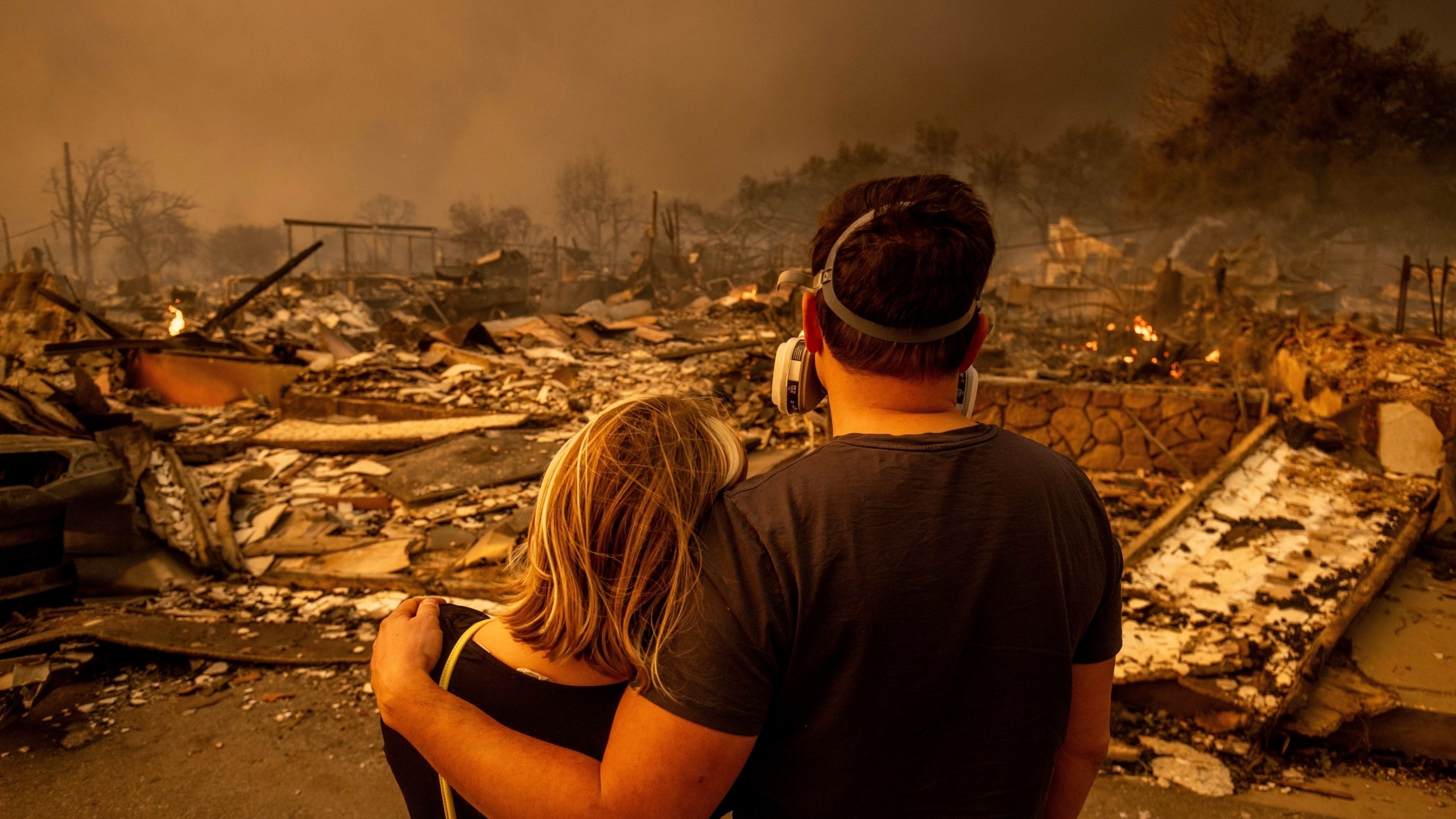 FILE - Megan Mantia, left, and her boyfriend Thomas, only first game given, return to Mantia's fire-damaged home after the Eaton Fire swept through the area, Jan. 8, 2025, in Altadena, Calif. (AP Photo/Ethan Swope, File)
