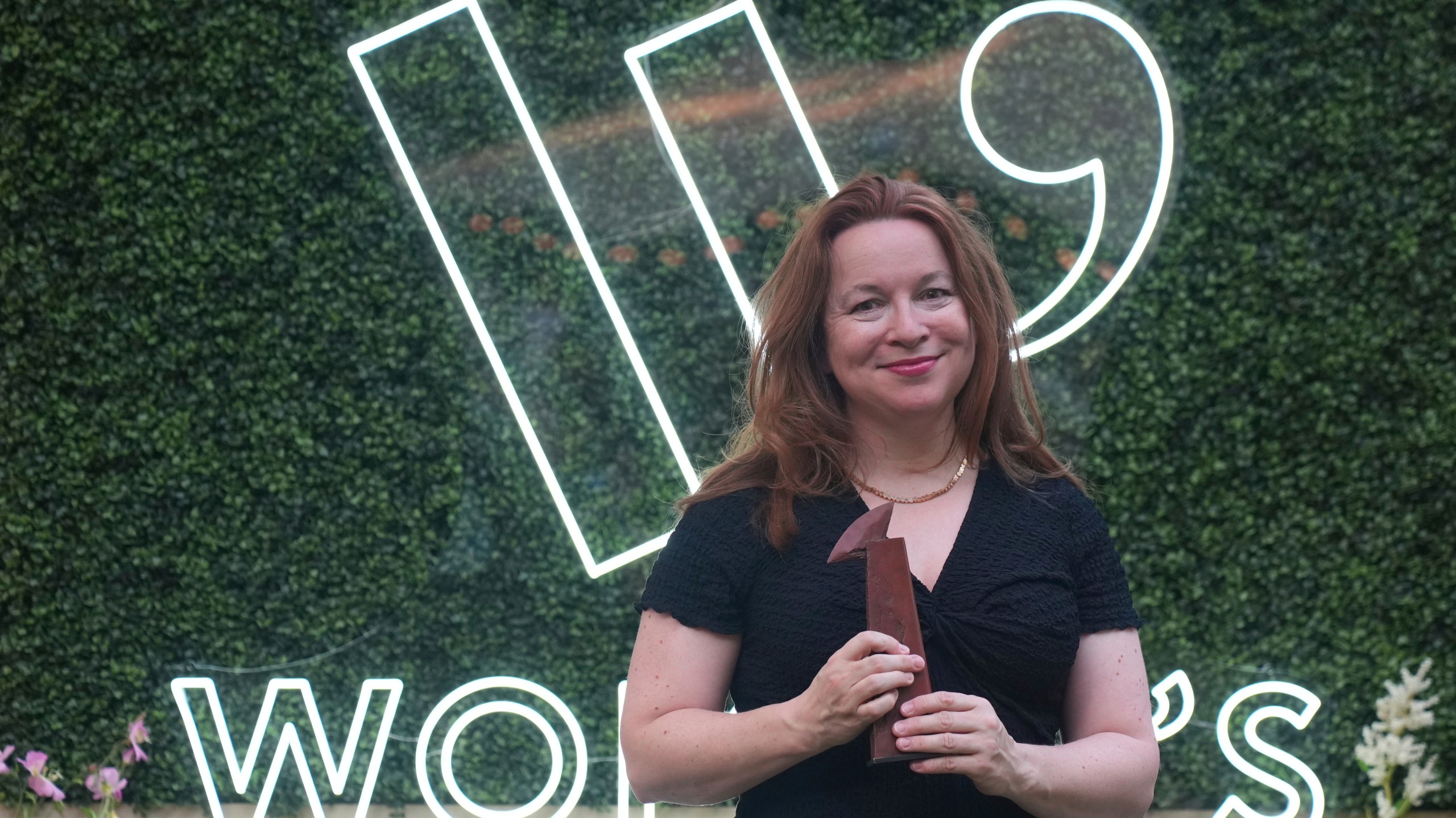Winner of the Women's Prize for Fiction Rachel Clarke for her book 'The Story of a Heart' holds her trophy as she poses for the media in London, Thursday, June 12, 2025. (AP Photo/Joanna Chan)