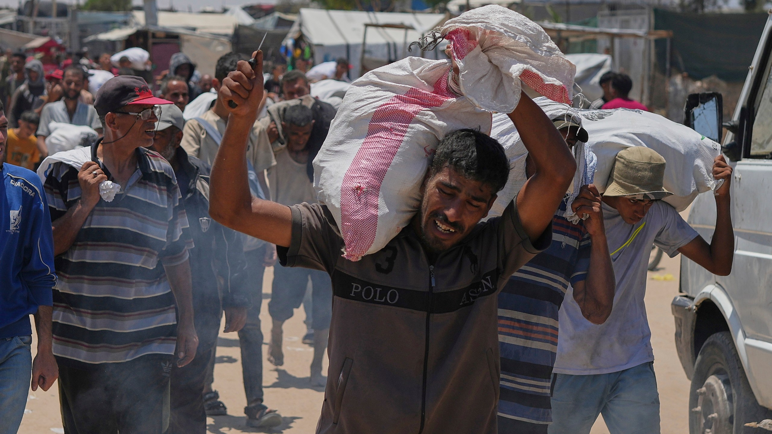 A Palestinian carries a bag containing food and humanitarian aid delivered by the Gaza Humanitarian Foundation, a U.S.-backed organization, in Rafah, southern Gaza Strip, Wednesday, June 11, 2025. (AP Photo/Abdel Kareem Hana)