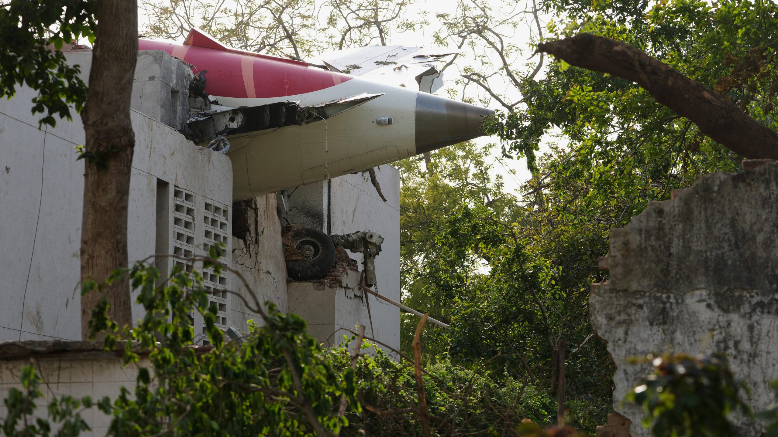 The tail of the airplane is seen stuck in a building at the site of an airplane that crashed in India's northwestern city of Ahmedabad in Gujarat state, Thursday, June 12, 2025. (AP Photo/Ajit Solanki)