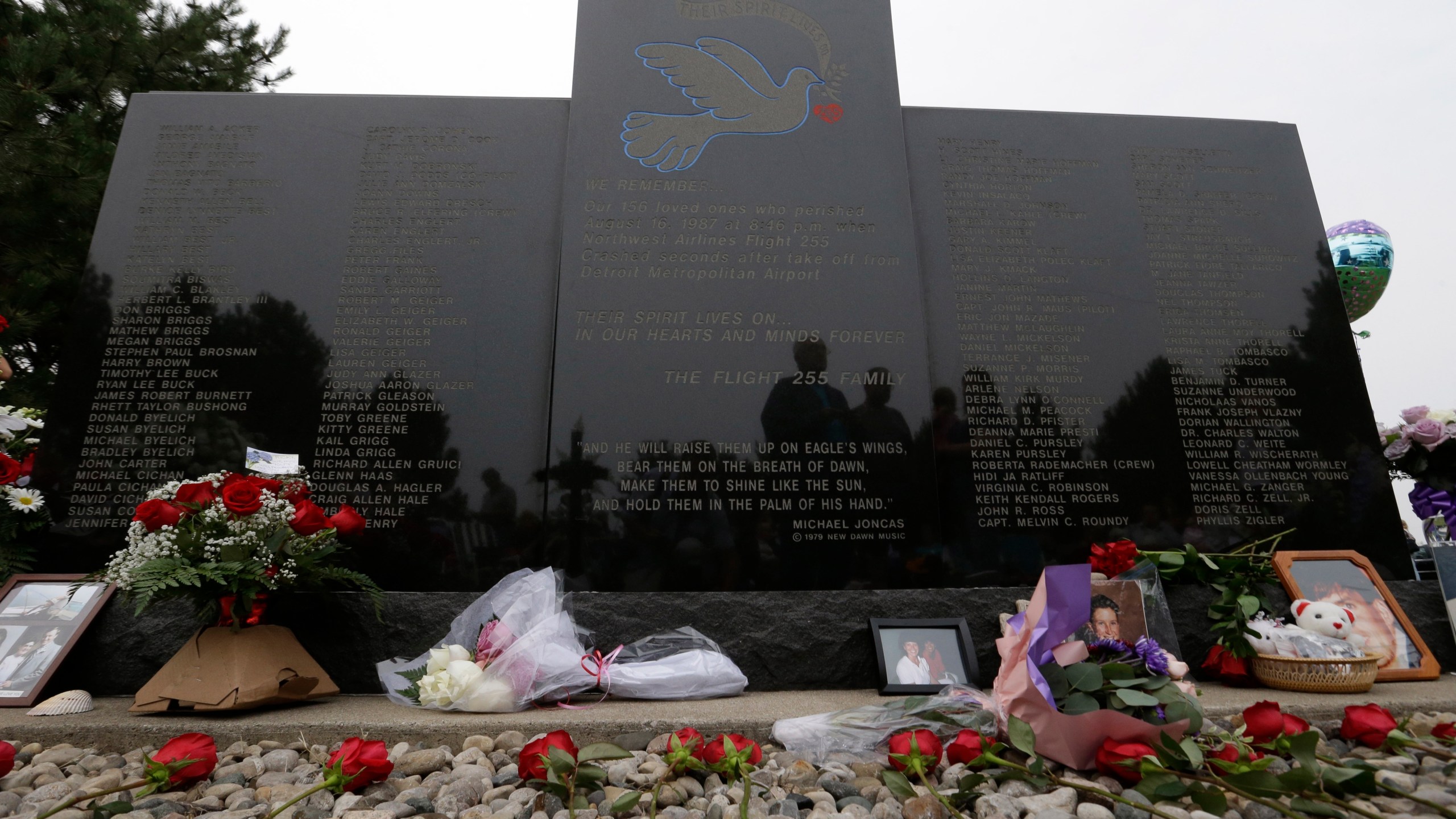 FILE - Flowers and pictures are shown at the memorial in Romulus, Mich., to mark the 25th anniversary of the crash of Northwest Airlines Flight 255 near Detroit Metropolitan Airport, Aug. 16, 2012. The MD-80 aircraft crashed in the Detroit suburb of Romulus, killing all 154 people aboard, except for a 4-year-old girl. Two people also died on the ground. (AP Photo/Paul Sancya, File)