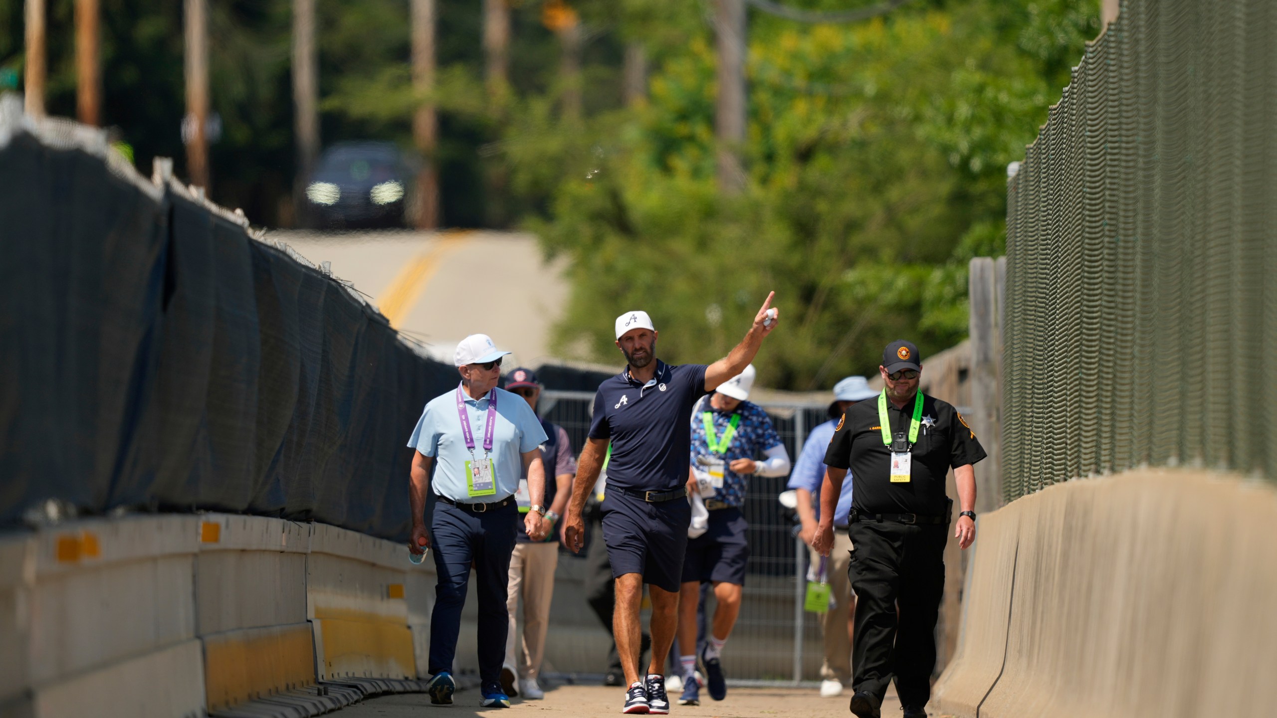 Dustin Johnson uses a pedestrian bridge over the Pennsylvania Turnpike, which divides Oakmont Country Club, during a practice round ahead of the U.S. Open golf tournament Wednesday, June 11, 2025, in Oakmont, Pa. (AP Photo/Carolyn Kaster)