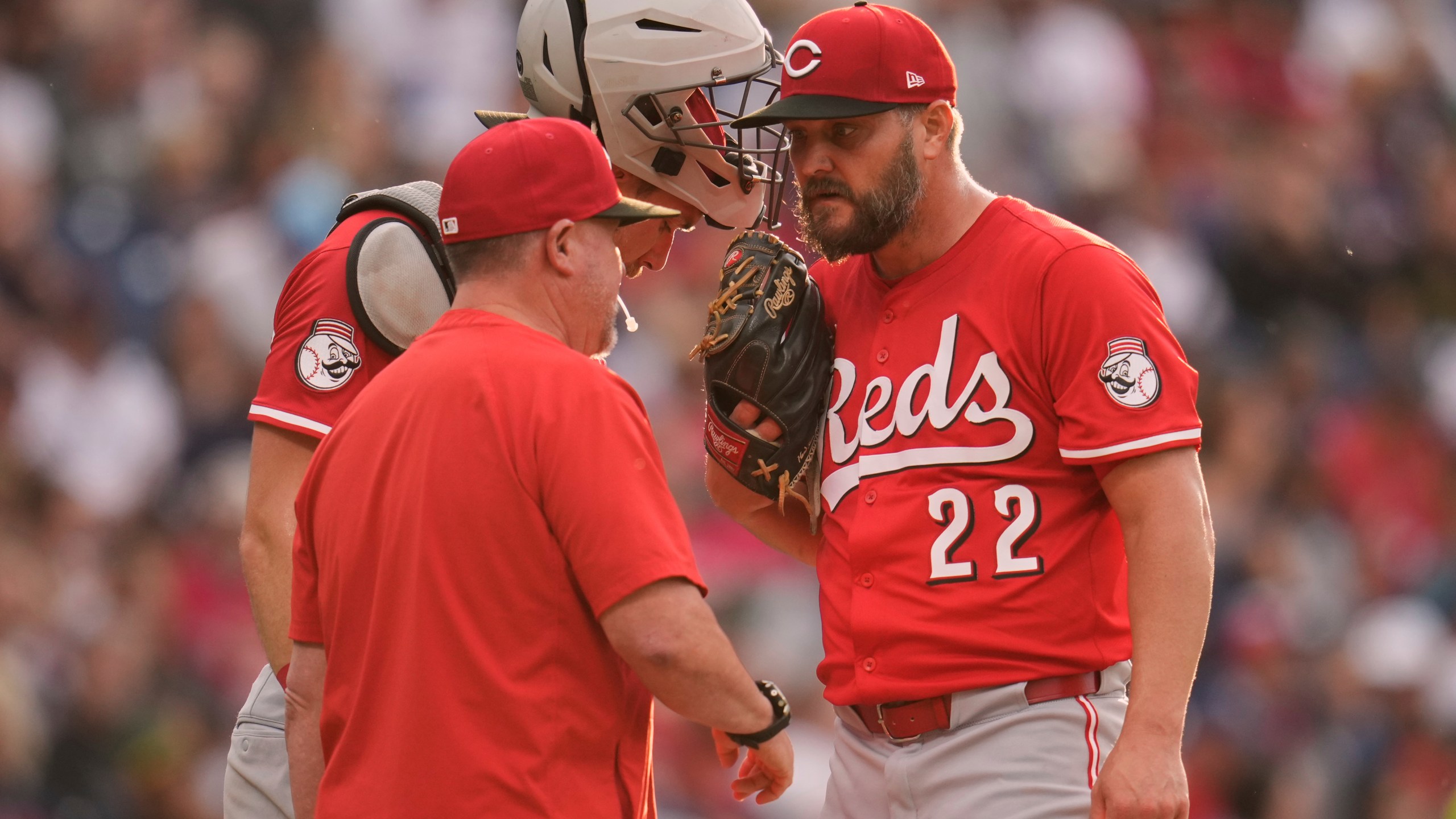 Cincinnati Reds pitching coach Derek Johnson, left, talks with catcher Tyler Stephenson, center, and starting pitcher Wade Miley (22) in the third inning of a baseball game in Cleveland, Monday, June 9, 2025. (AP Photo/Sue Ogrocki)