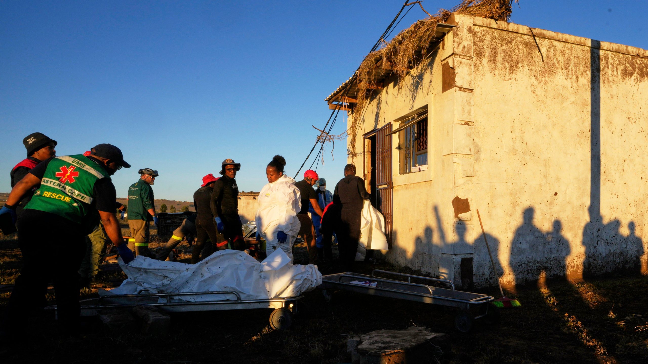 Forensic workers retrieve bodies of a mother and three daughters from inside a one room house after floods swept through the area in Mthatha, South Africa, Thursday, June 12, 2025. (AP Photo/Themba Hadebe)