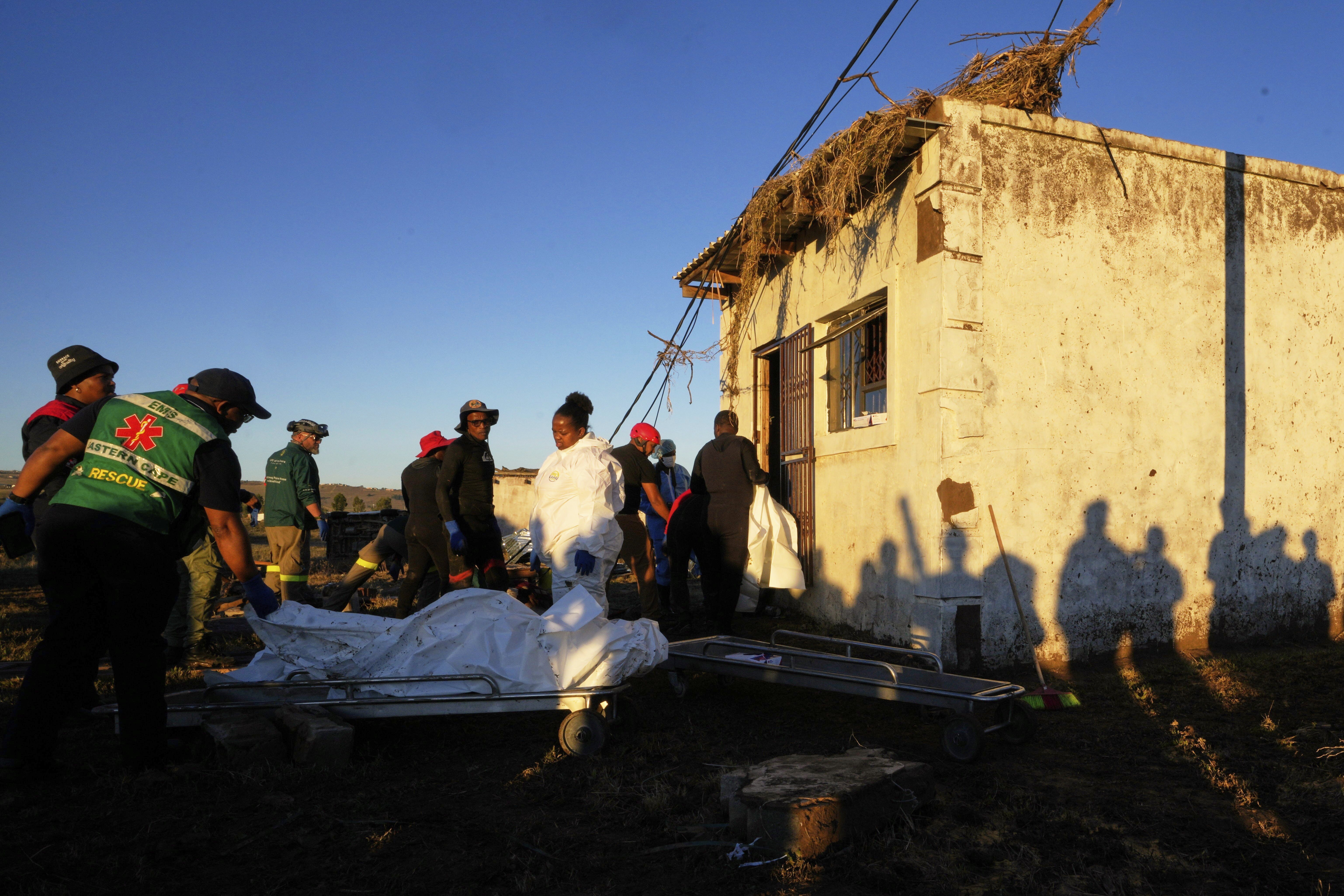 Forensic workers retrieve bodies of a mother and three daughters from inside a one room house after floods swept through the area in Mthatha, South Africa, Thursday, June 12, 2025. (AP Photo/Themba Hadebe)