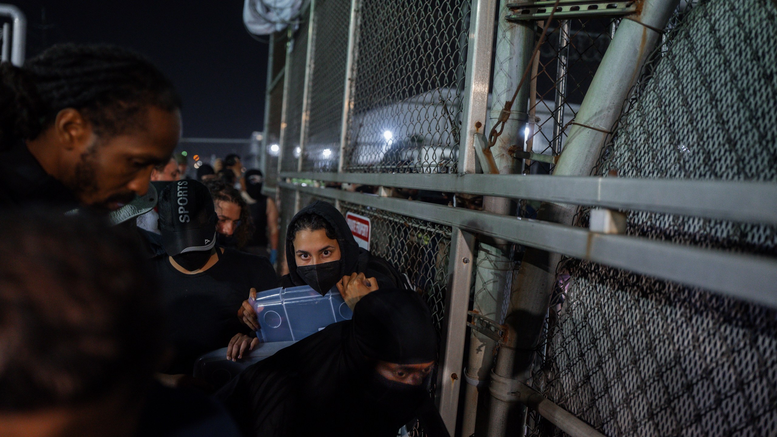 A Protester shouts at an Immigration and Customs Enforcement (ICE) officer through the gate of the Delaney Hall Immigration Facility during a protest over federal immigration enforcement raids on Thursday, June 12, 2025, in Newark, N.J. (AP Photo/Olga Fedorova)