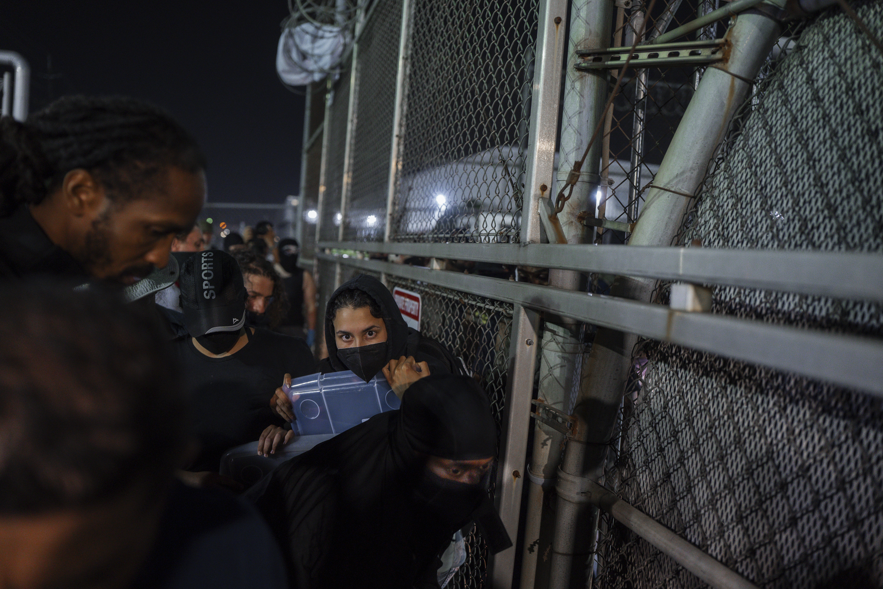 A Protester shouts at an Immigration and Customs Enforcement (ICE) officer through the gate of the Delaney Hall Immigration Facility during a protest over federal immigration enforcement raids on Thursday, June 12, 2025, in Newark, N.J. (AP Photo/Olga Fedorova)