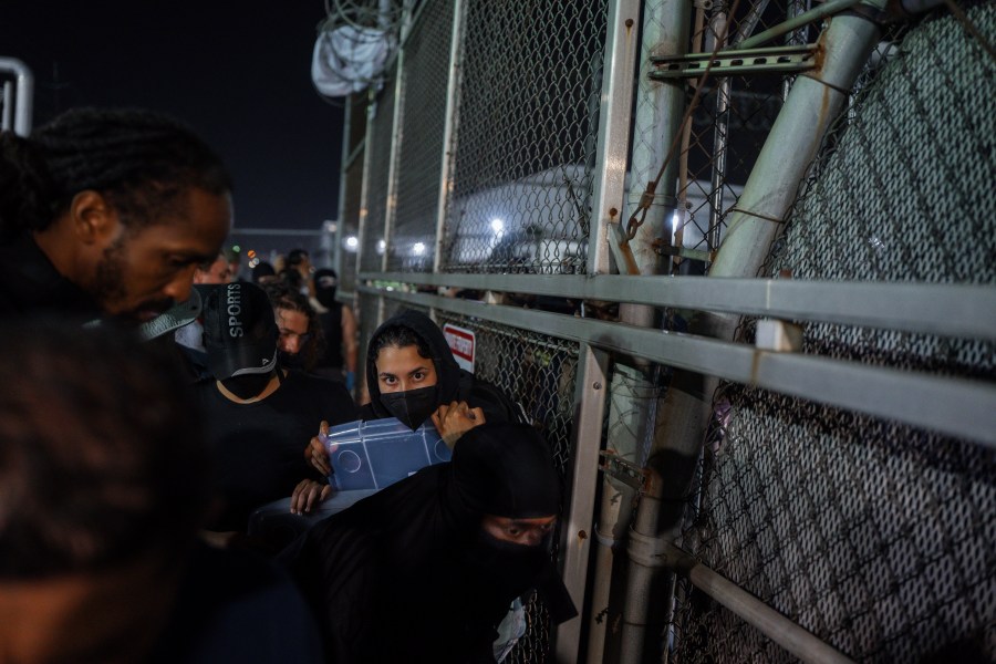 A Protester shouts at an Immigration and Customs Enforcement (ICE) officer through the gate of the Delaney Hall Immigration Facility during a protest over federal immigration enforcement raids on Thursday, June 12, 2025, in Newark, N.J. (AP Photo/Olga Fedorova)