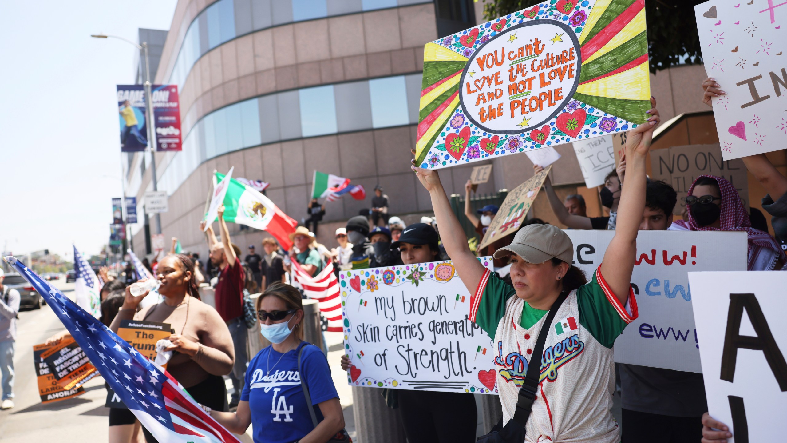 Demonstrators hold signs during a protest, Thursday, June 12, 2025, in Los Angeles. (AP Photo/Etienne Laurent)