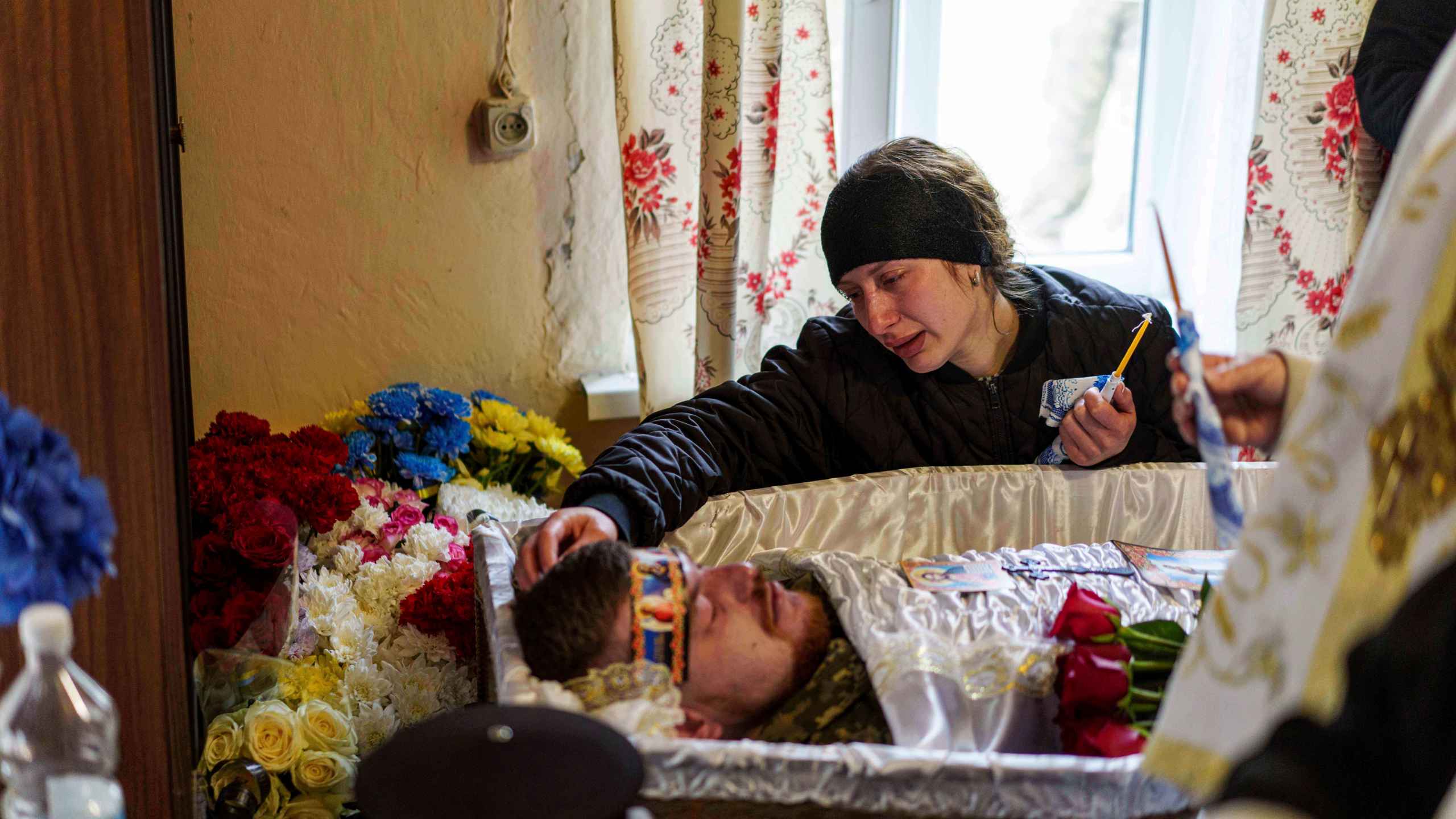 Olena cries at the coffin of her husband, Dmytro Shapovalov, a Ukrainian serviceman, during his funeral ceremony in Yosypivka village, Vinnytsia region, Ukraine, on Friday, June 13, 2025. (AP Photo/Evgeniy Maloletka)