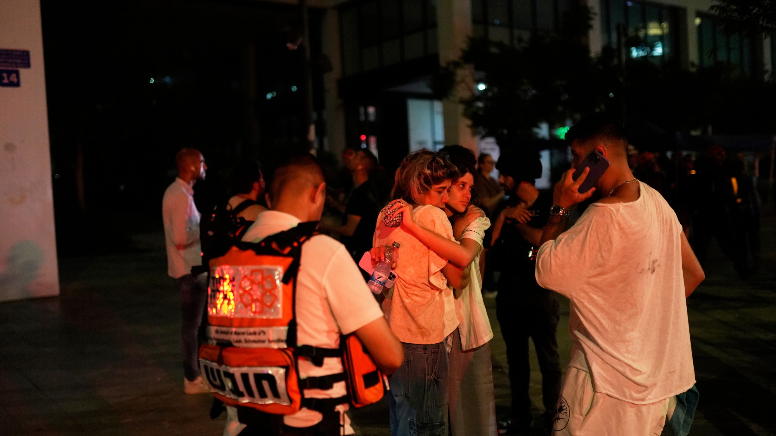 People react next to a building struck by a missile fired from Iran, in Tel Aviv, Israel, on Friday, June 13, 2025. (AP Photo/Tomer Appelbaum)