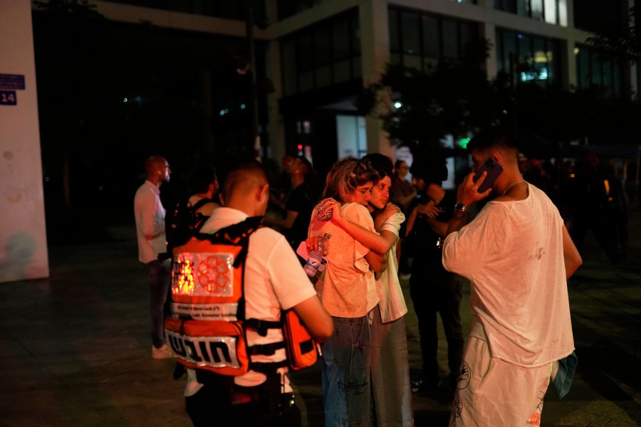 People react next to a building struck by a missile fired from Iran, in Tel Aviv, Israel, on Friday, June 13, 2025. (AP Photo/Tomer Appelbaum)