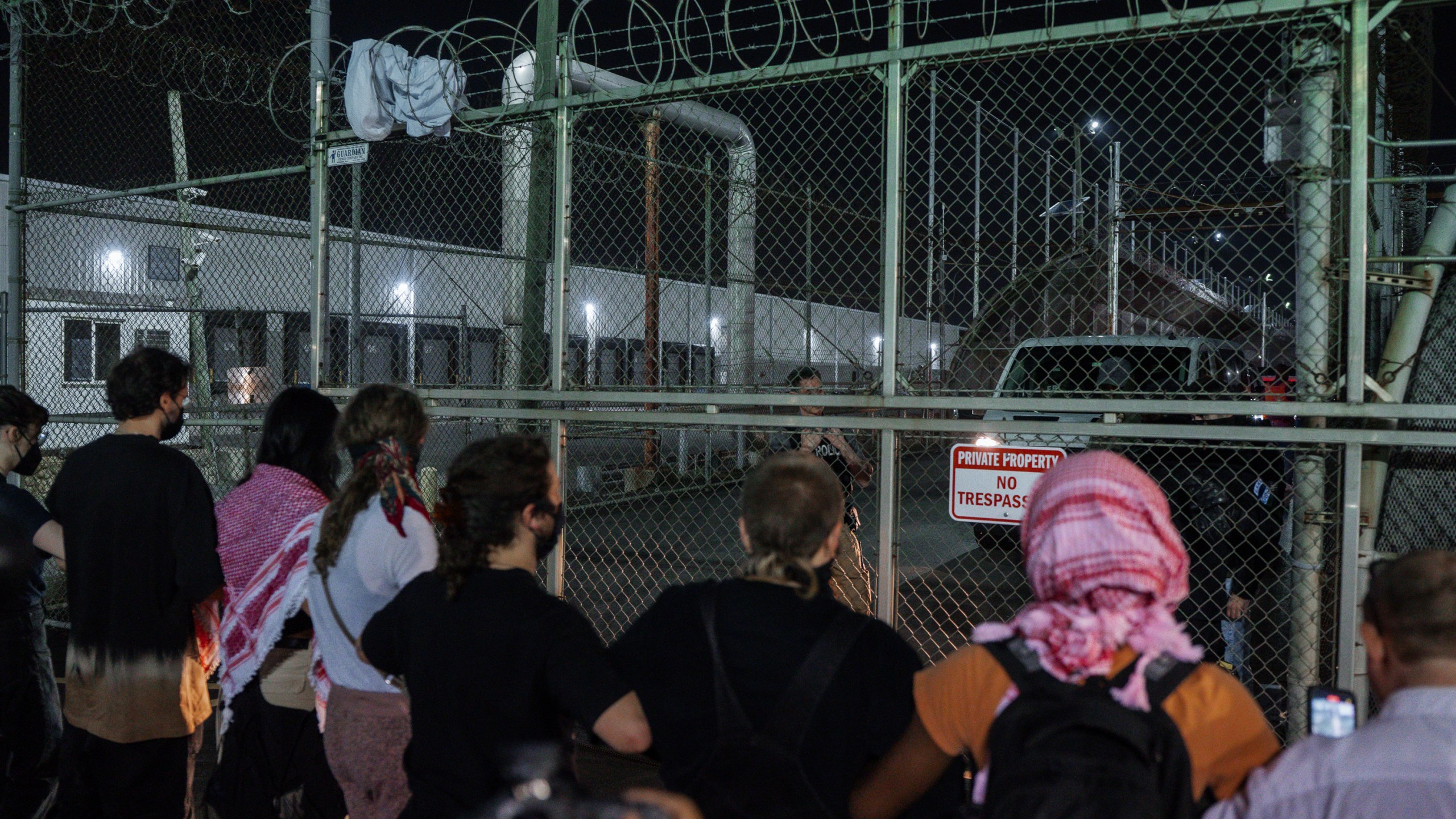 Protesters link hands at the gates of the Delaney Hall Detention Facility to prevent vehicles from exiting during protests over federal immigration enforcement raids on Thursday, June 12, 2025, in Newark, N.J. (AP Photo/Olga Fedorova)