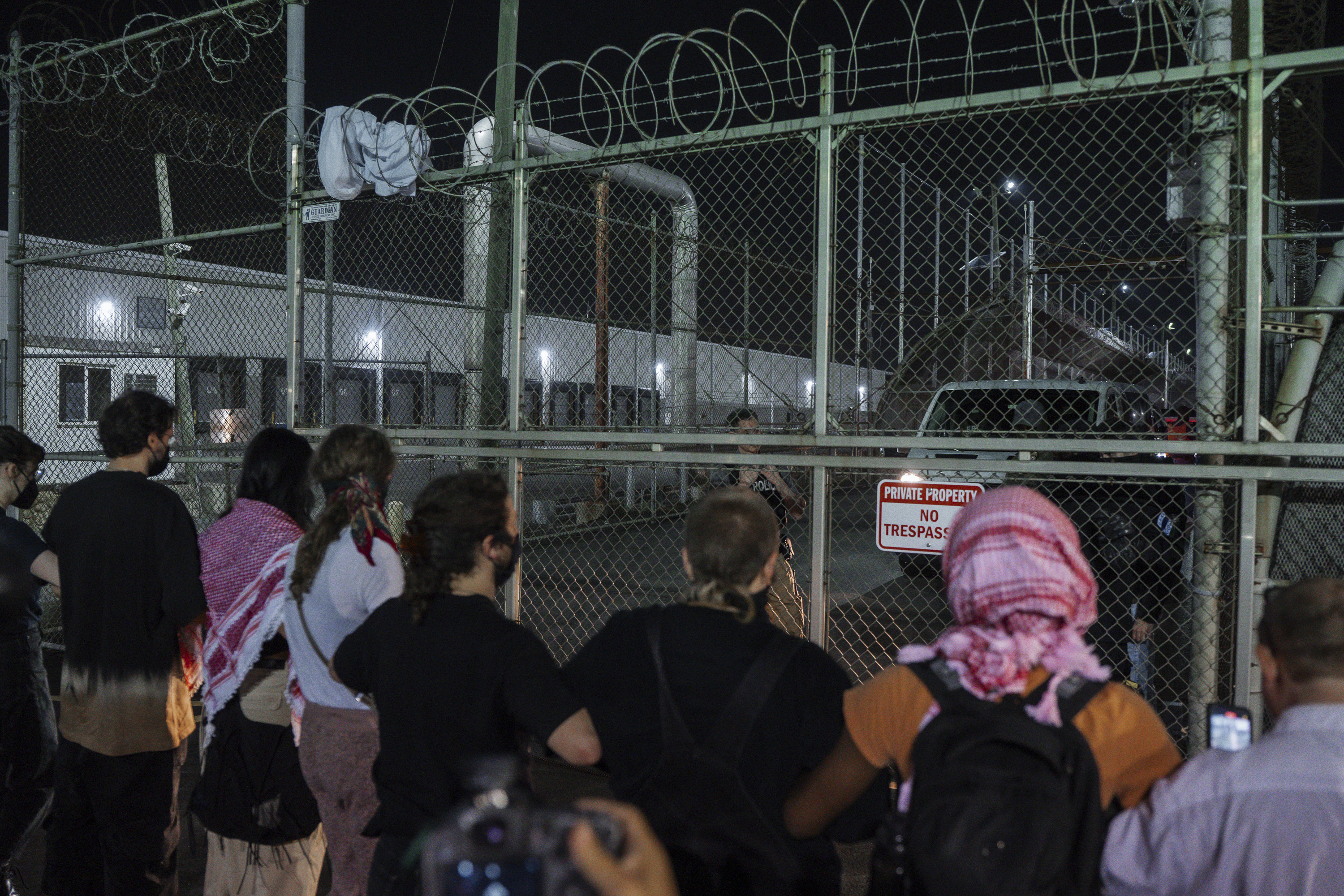 Protesters link hands at the gates of the Delaney Hall Detention Facility to prevent vehicles from exiting during protests over federal immigration enforcement raids on Thursday, June 12, 2025, in Newark, N.J. (AP Photo/Olga Fedorova)
