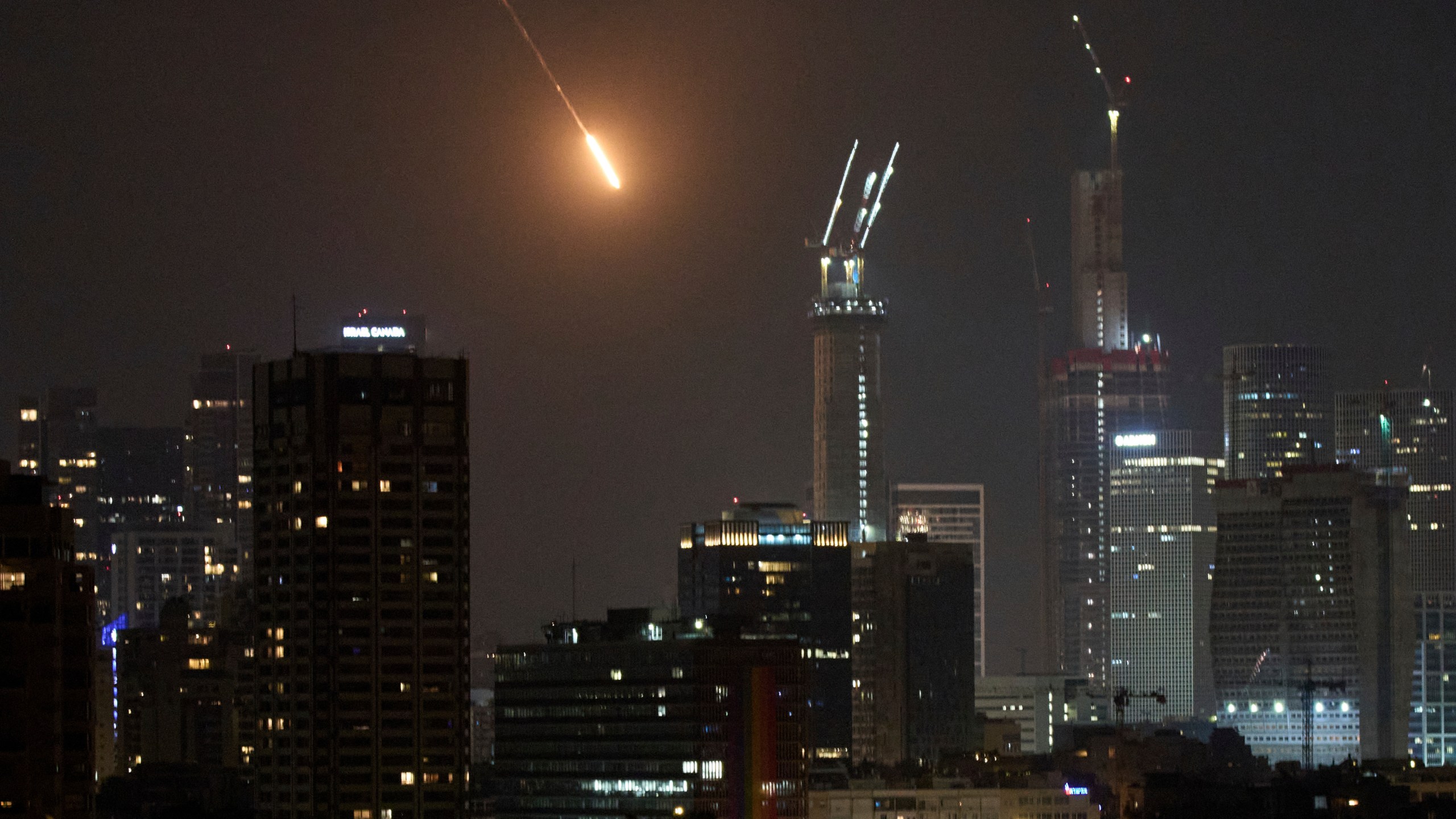 The trace of a projectile is seen before hitting Tel Aviv, Israel, early Saturday, June 14, 2025. (AP Photo/Leo Correa)