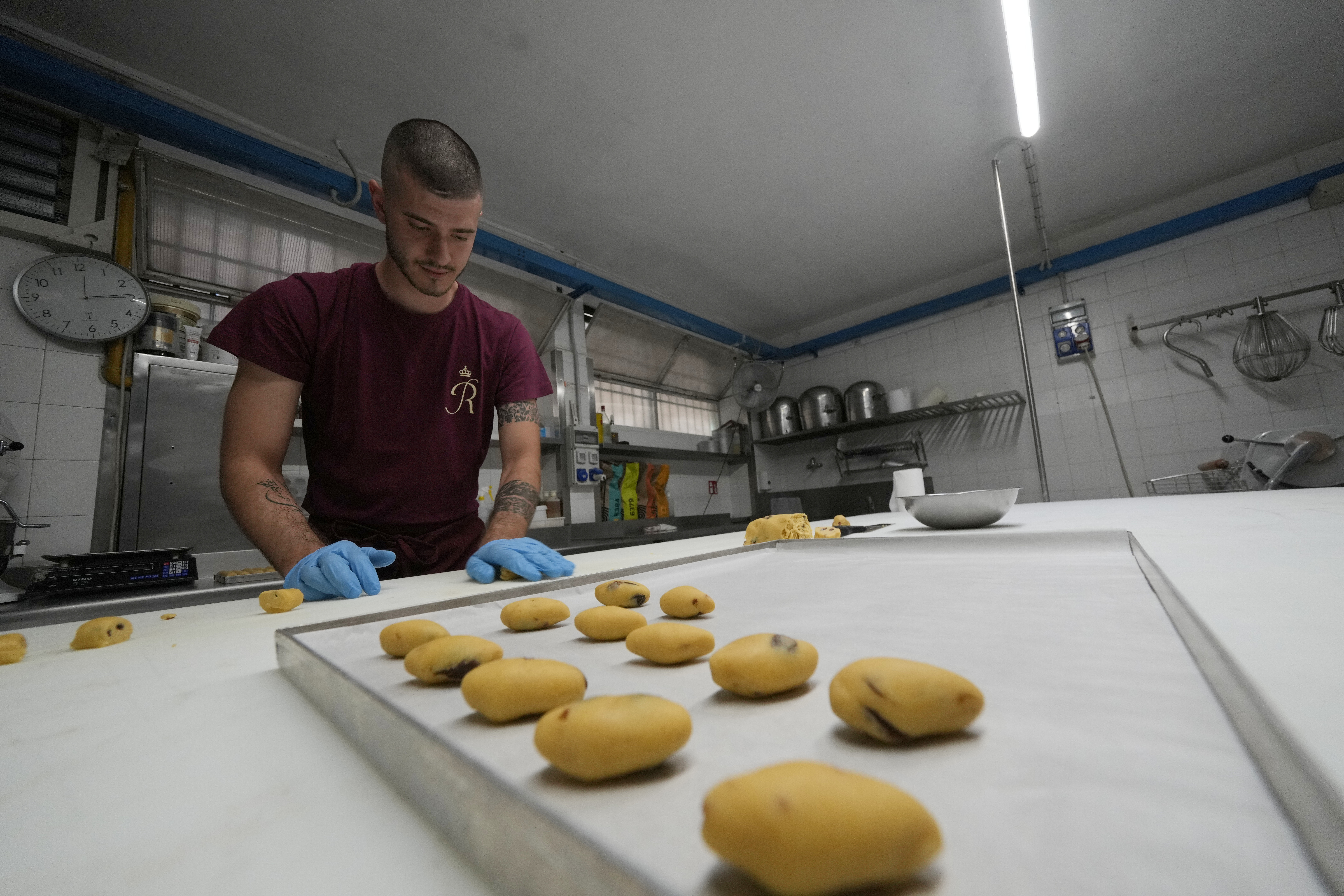 Pastry chef Elias prepares traditionals Zaletti biscuits at the Andrea Rosa Salva pastry kitchen, in Venice, Italy, Thursday, June 12, 2025. (AP Photo/Luca Bruno)