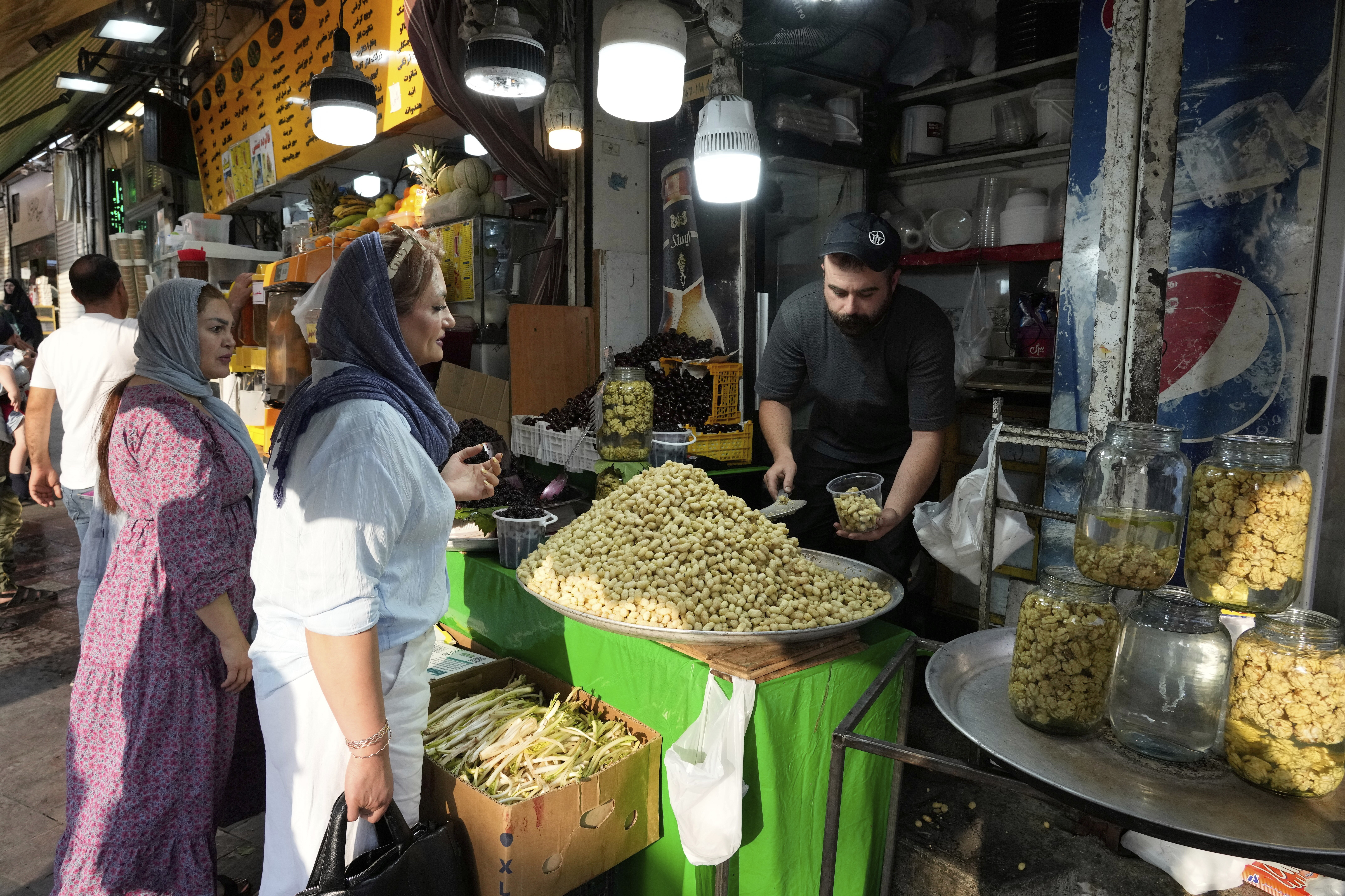 A fruit seller sells Mulberry at Tajrish traditional bazaar in northern Tehran, Iran, Friday, June 13, 2025. (AP Photo/Vahid Salemi)