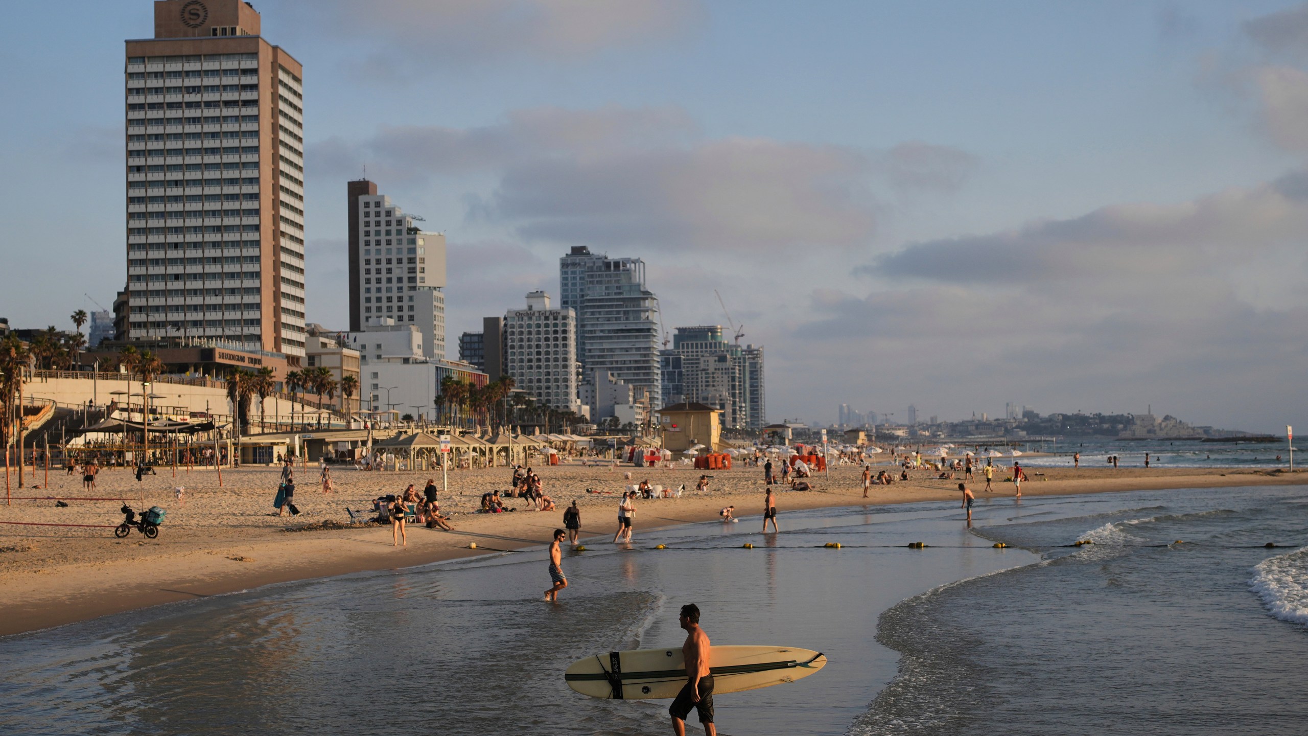 People spend the day on the Mediterranean Sea beachfront in Tel Aviv, Israel, on Saturday, June 14, 2025. (AP Photo/Ohad Zwigenberg)